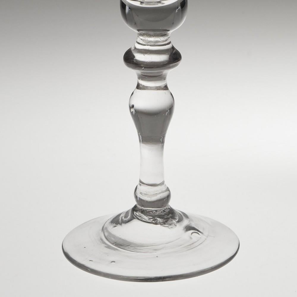 Heading : Engraved light baluster Georgian wine glass
Period : George II - c1750
Origin : England
Colour : Clear
Bowl : Bell - engraved with a band of fruiting vines
Stem : Flattned knop, inverted baluster, ball knop cushion
Foot : Conical
Pontil :