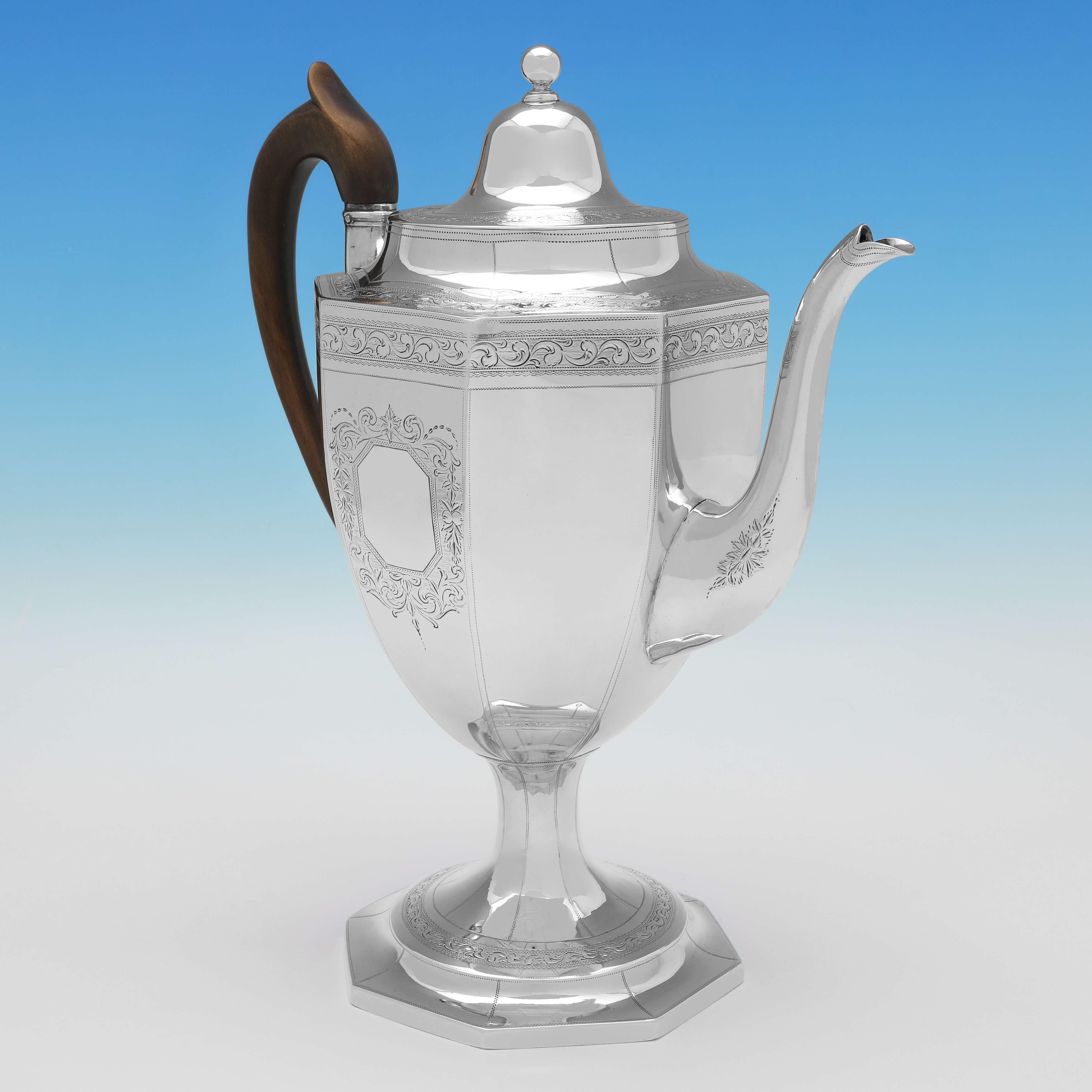 Hallmarked in London in 1801 by George Smith II & Thomas Hayter, this large and fine quality, George III, Antique Sterling Silver Coffee Pot, is octagonal in shape, standing on a pedestal foot, and features a wooden handle and bright cut engraved