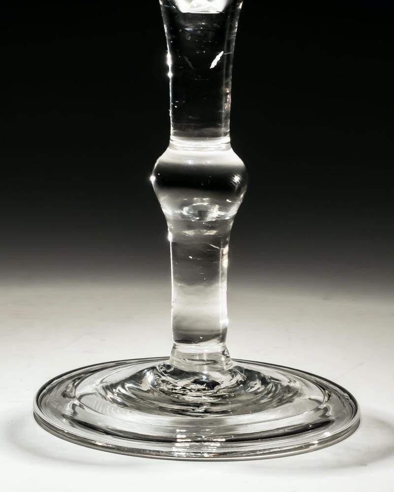 Ein graviertes Weinglas mit einfachem Stiel.

England, um 1750.

Höhe: 15 cm (6