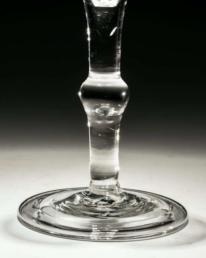 An engraved plain stem wine glass.

England, circa 1750.

Height: 15 cm (6