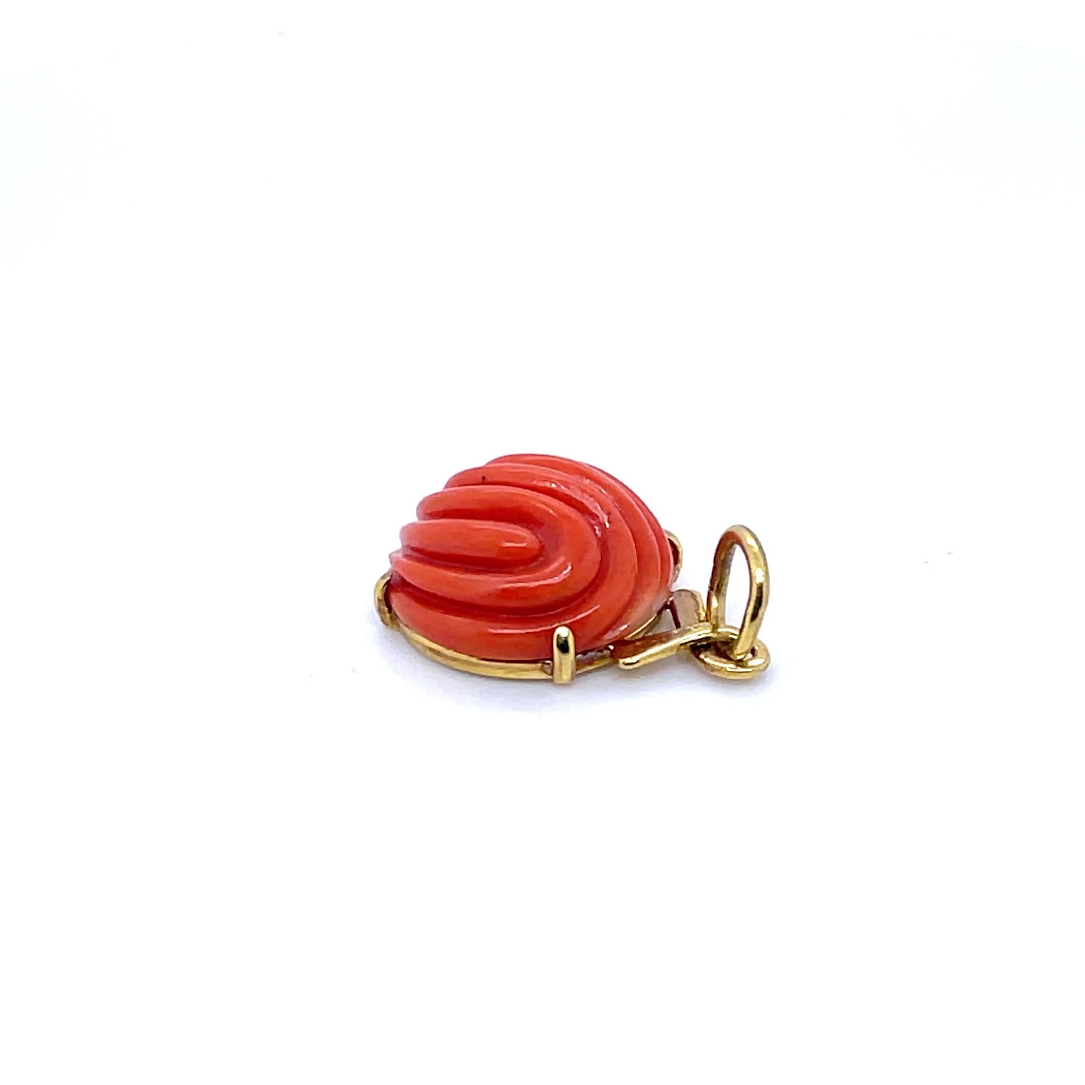 Questo squisito pezzo è caratterizzato da un cabochon di corallo rotondo, che offre uno splendido tocco di tonalità rosso-arancio, audace e bellissimo. 

L'intricata incisione intorno alla pietra aggiunge un tocco di raffinatezza, rendendola un
