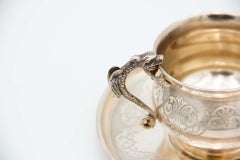 Engraved silver teacup and saucer