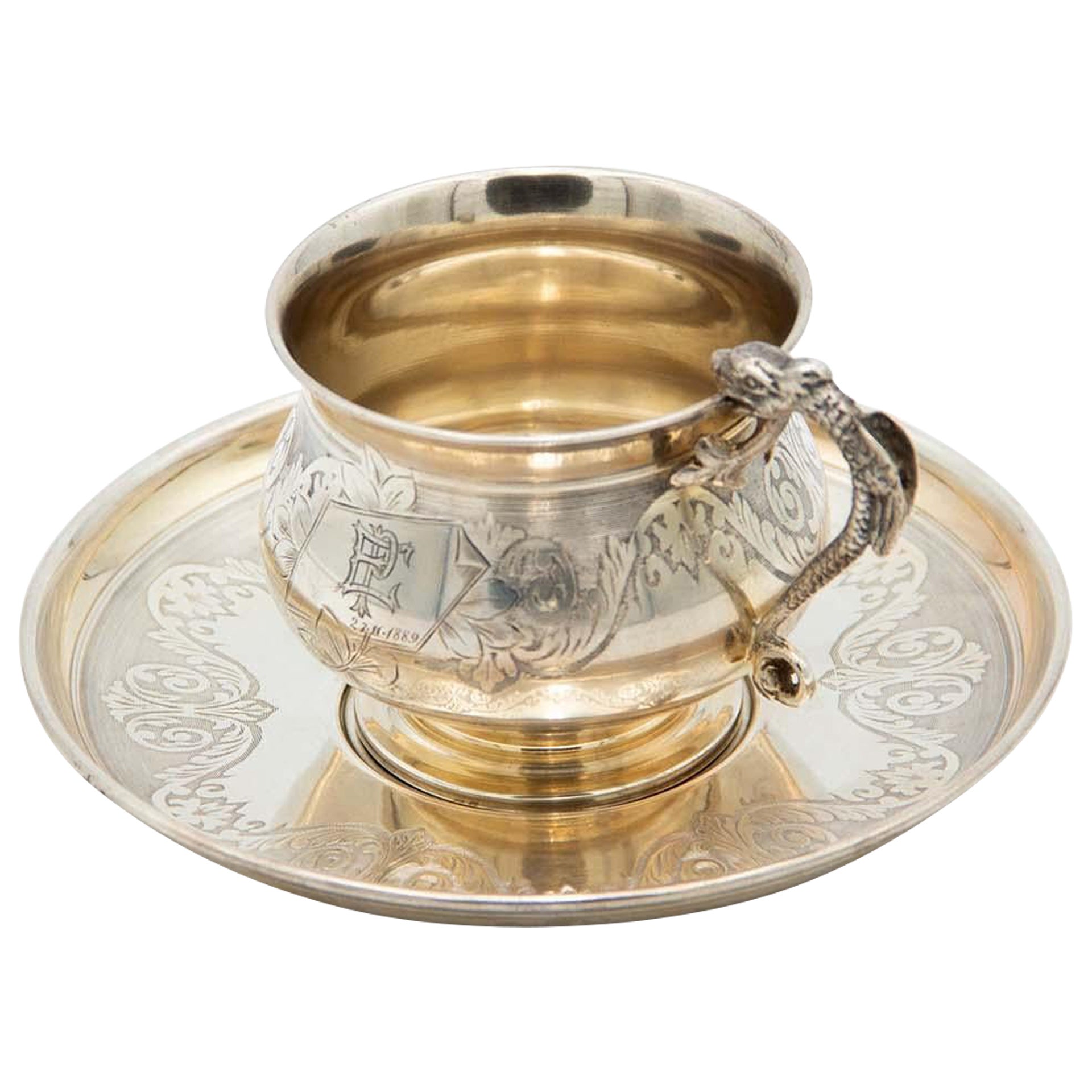 Engraved silver teacup and saucer