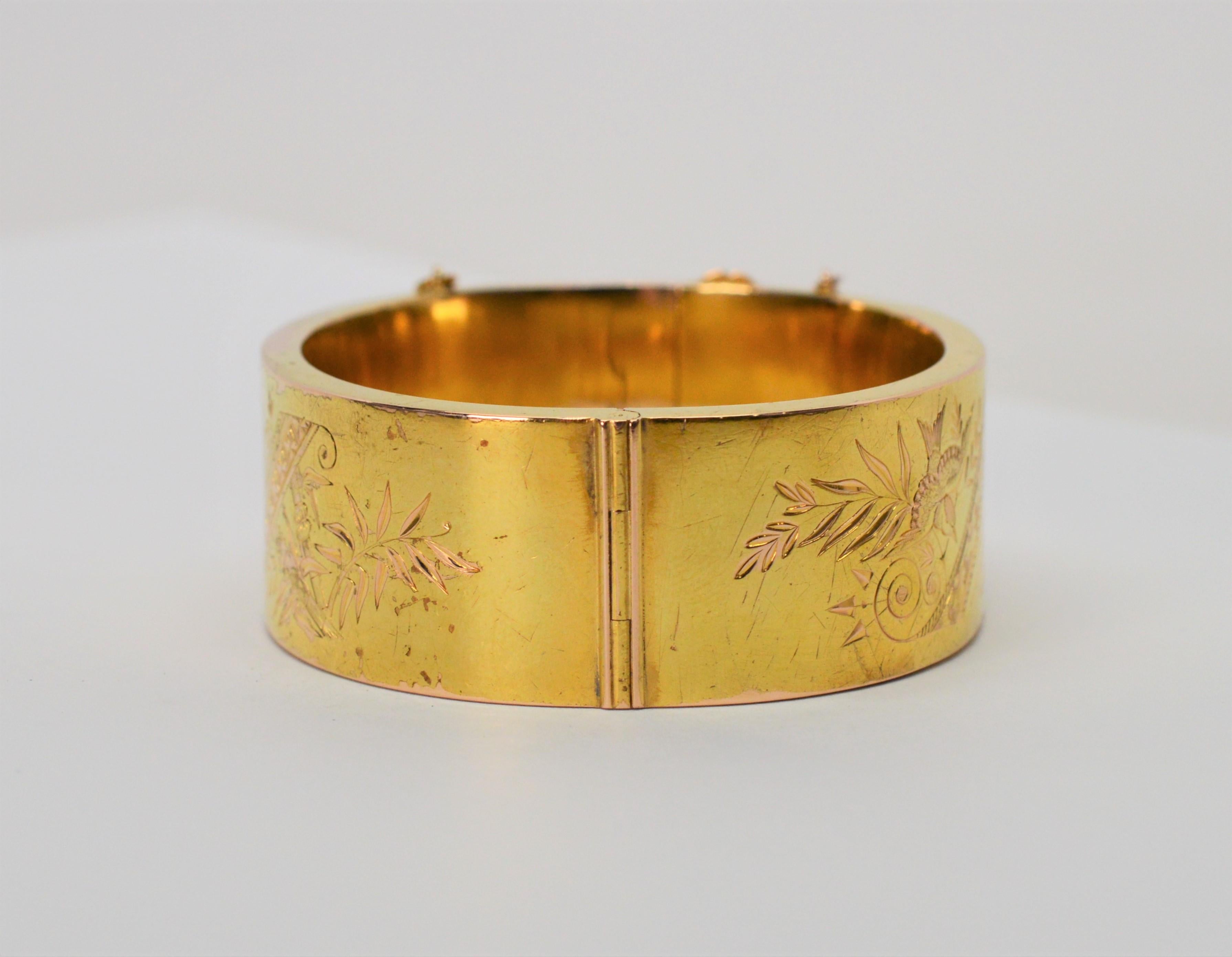 Elegant, with decorative engraving on both front and back, this antique piece is in fourteen carat (14K) polished yellow gold. For smaller wrists, measuring  2-1/8 x 1-3/4 inches or a 6 inch circumference, the bracelet is hinged for easier on/off