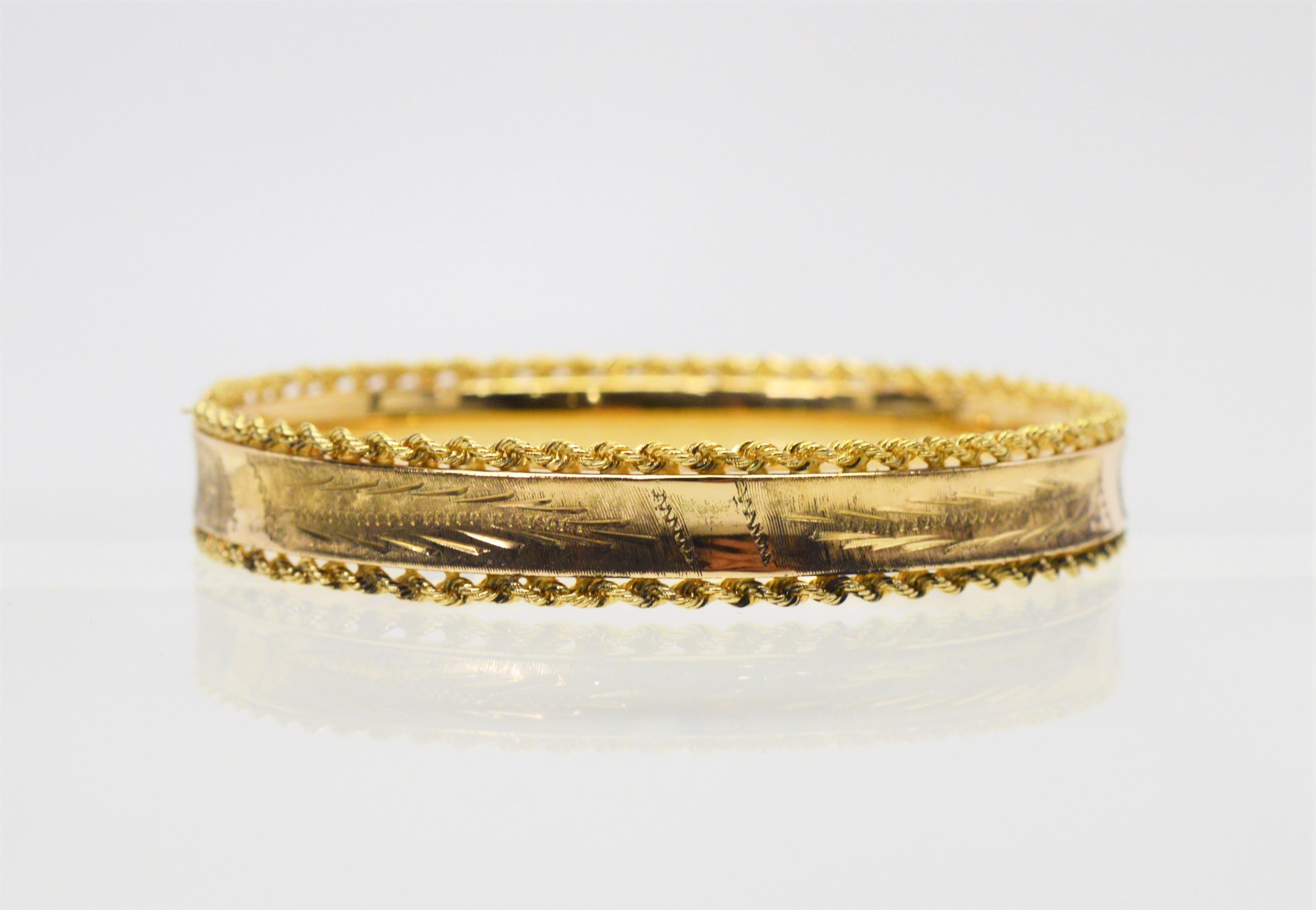 Fourteen karat yellow gold and trimmed with a pretty rope chain detail, this circa 1960's bangle bracelet is engraved with a wheat design, known as a symbol of abundance, life and fertility.  The diameter is 2-3/8 x 2 inches and the bracelet is