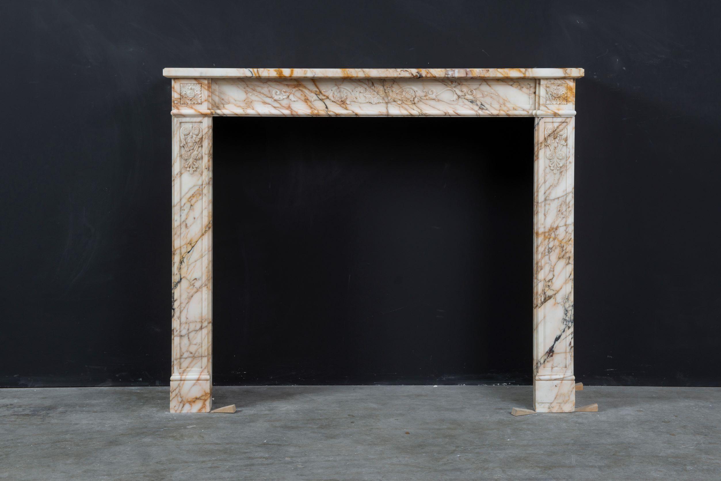 Pleased to offer this enjoyable antique Louis XVI fireplace mantel.

Lovely decorative French Louis XV fireplace mantel in decorative soft toned colorful marble.
The pleasantly colored and veined marble, subtle floral and paneled decorations make