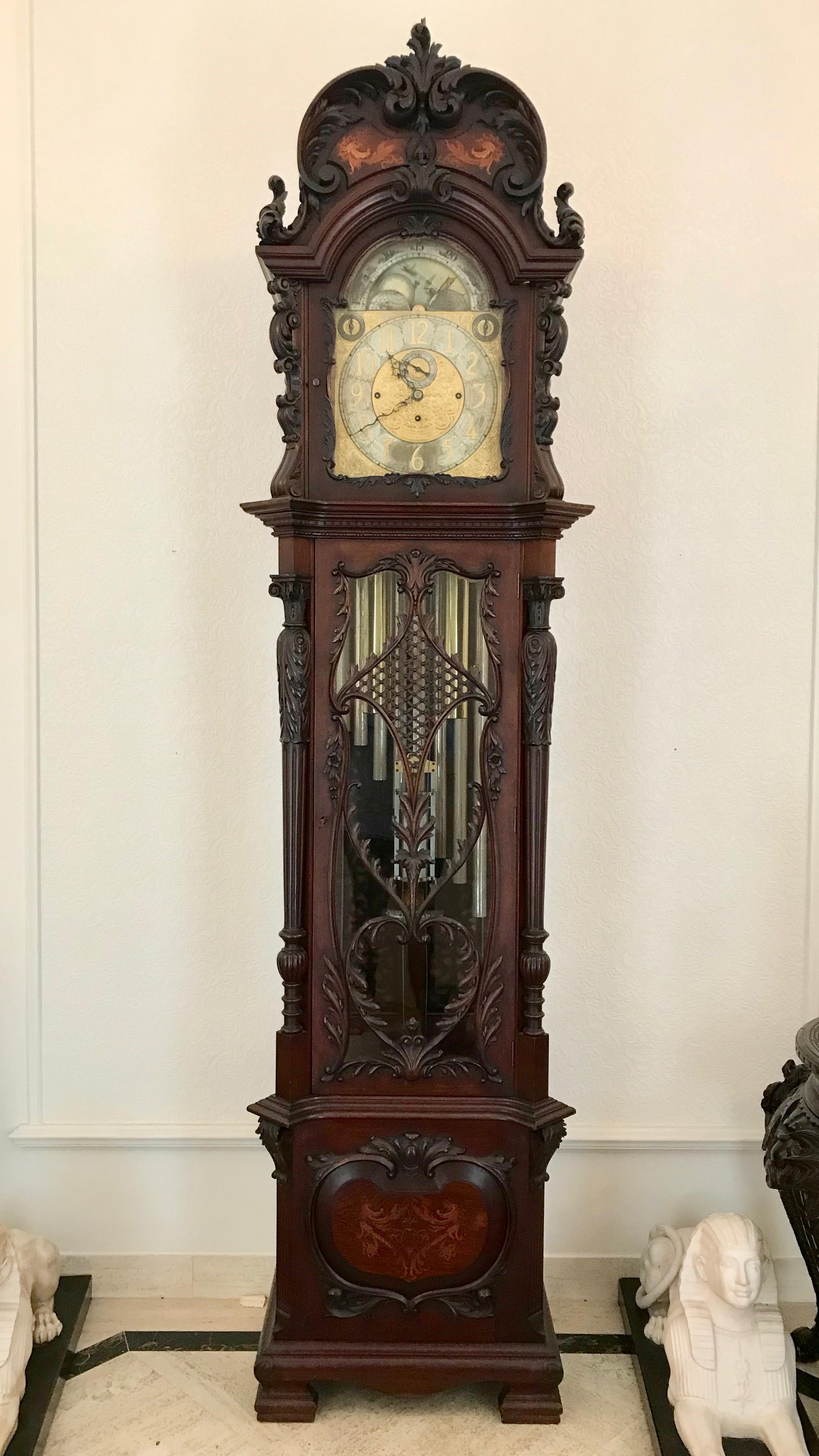 The clock is formed with an elaborate richly carved case featuring elaborate
fret work and exotic inlays at its crown.
The 