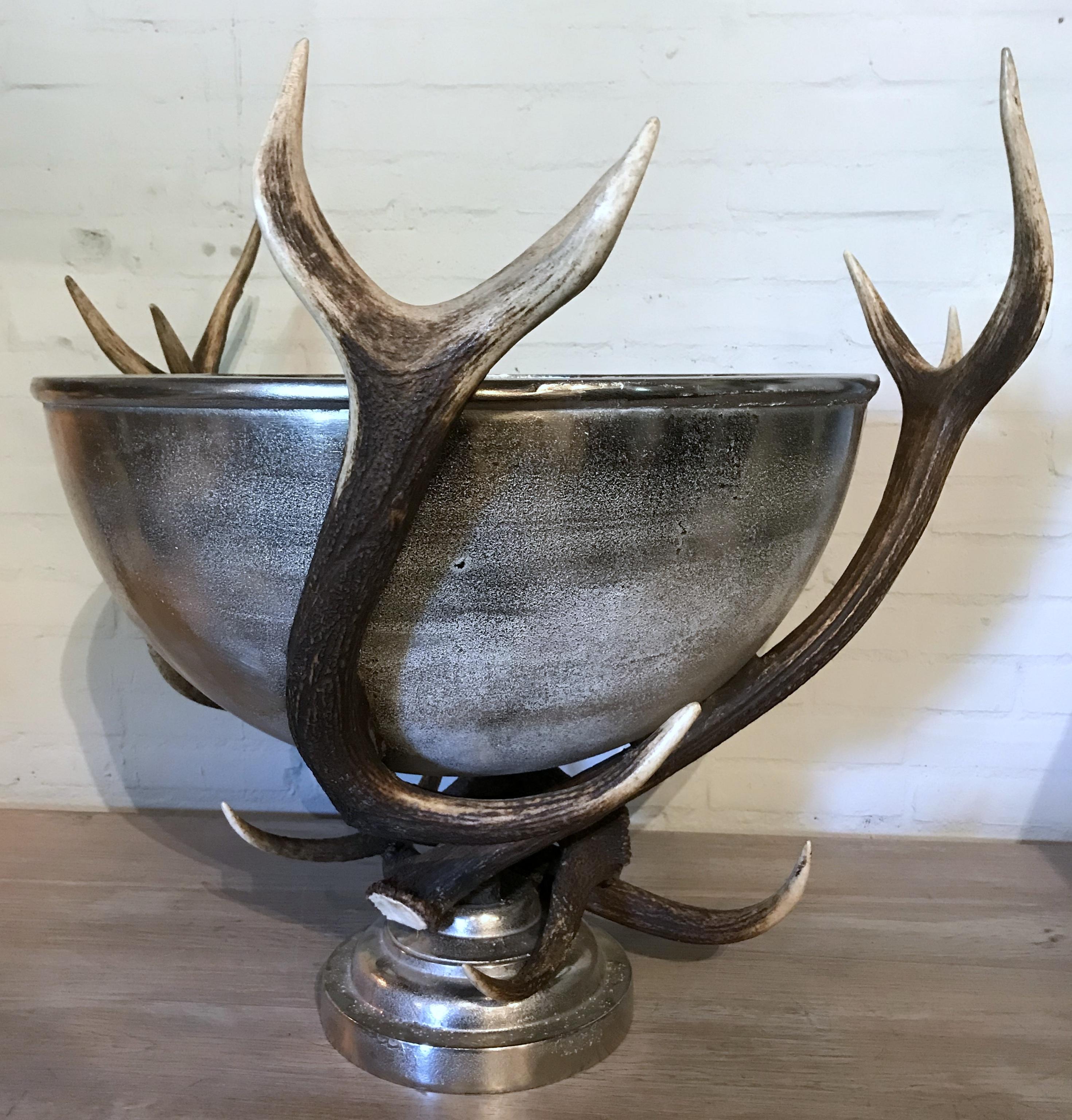 Enormous champagne cooler made of red deer antler. The bowl is made of robust nickel-plated metal.
Very decorative piece to fill up with ice and bottles of wine or champagne. The bowl has a diameter of 59 cm.