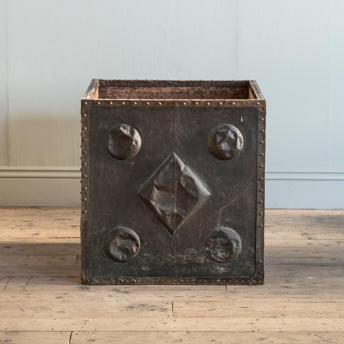 An Enormous Early 20th Century Copper and Brass Clad Log Bin with circular and diamond shaped embossed panels to two of the four sides, and overall muted and sleepy surface patina.

Additional information:
Dimension: Height: 80 cm, 31 1/2″
Width: 77