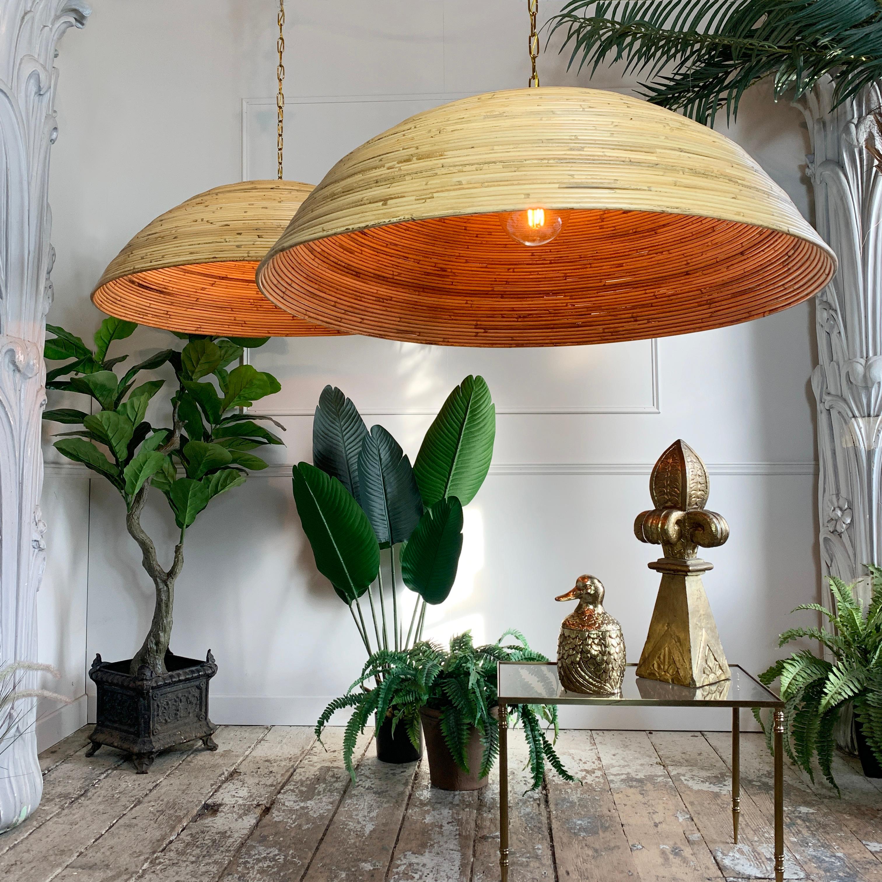 An incredible pair of enormous rattan dome ceiling pendants, iconic 1960's Italian designer. Each of the pendants spanning over 90cm in diameter, with original brass fittings to the tops and inside the shades. 

Both pendants are in superb
