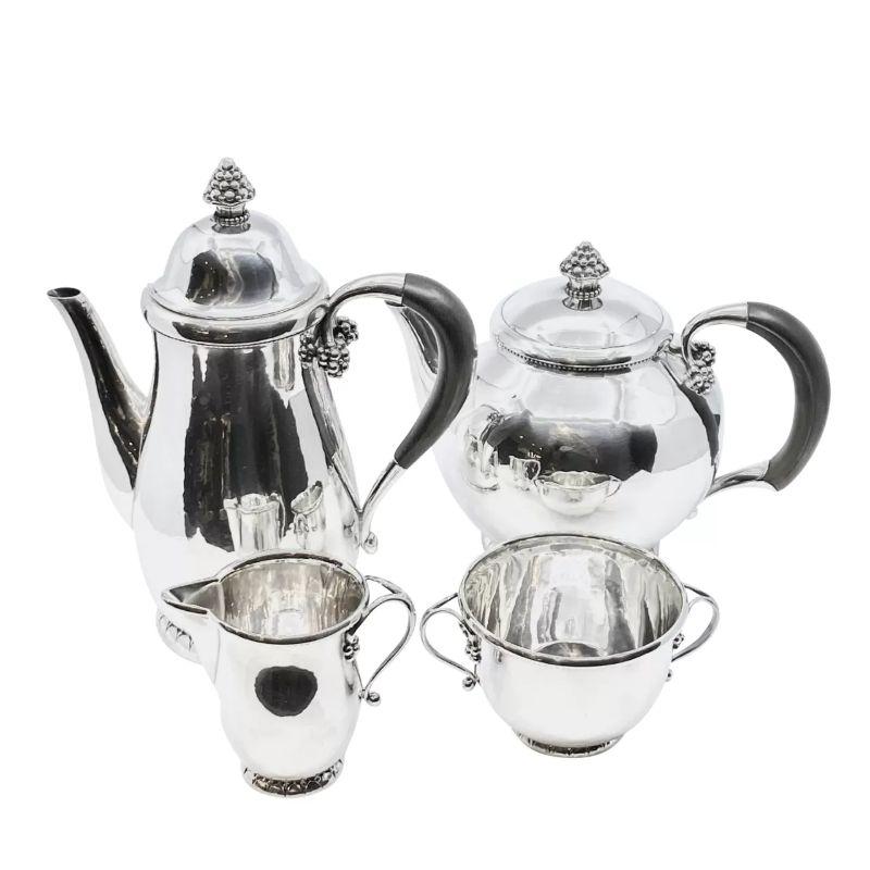 This exquisite tea set is a remarkable example of Danish art nouveau craftsmanship. Created by Georg Jensen in 1912, it showcases the iconic grape design, characterized by its elegant and ornate detailing. What sets this set apart is its