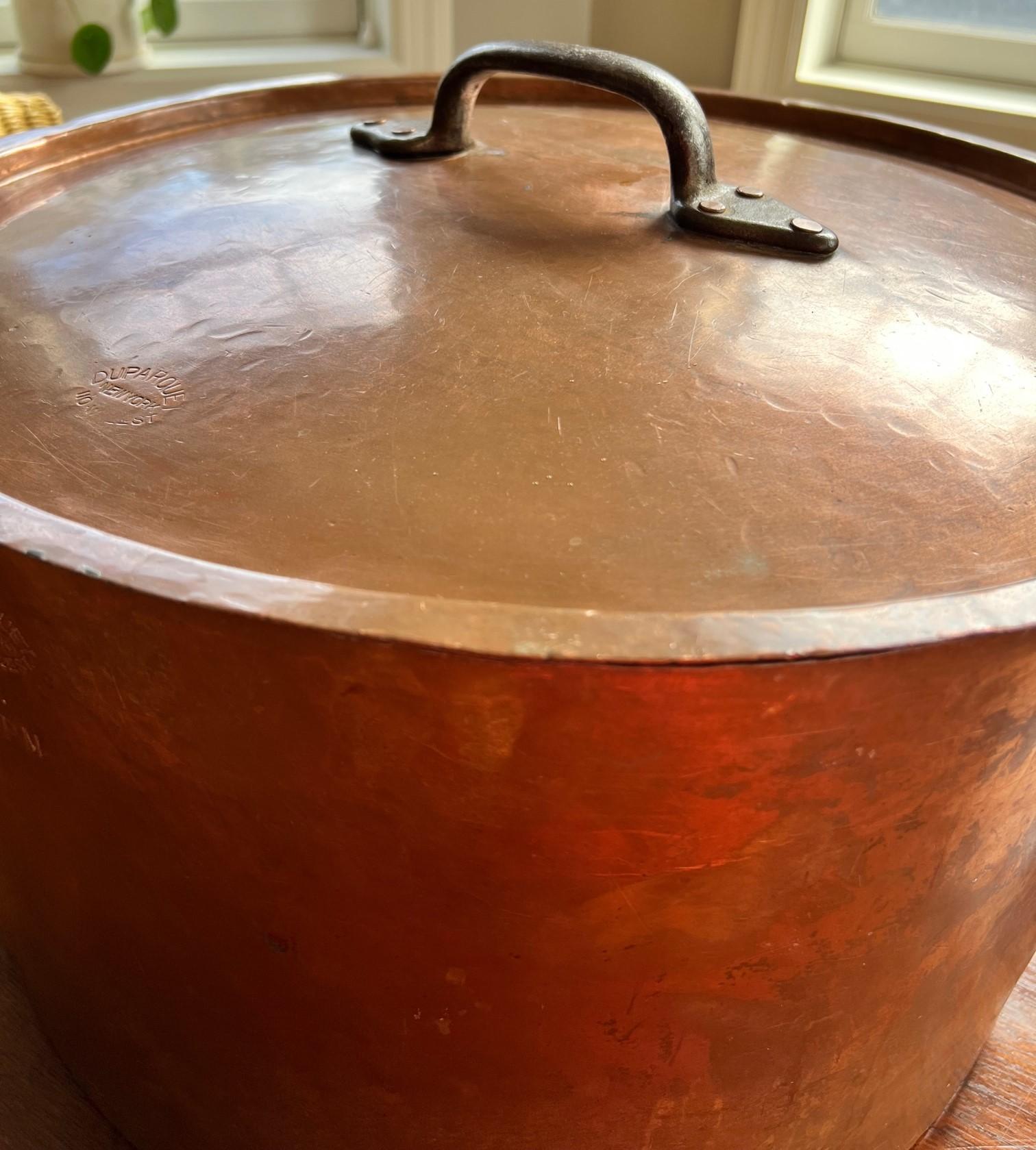Circa early 20th C, New York, from Duparquet, 110 W 22nd St, an enormous and heavy (40lbs) copper stock pot with two wrought iron handles and a fitted lid with a top wrought iron handle. 

The Duparquet stamp is evident on two sides of the pot and