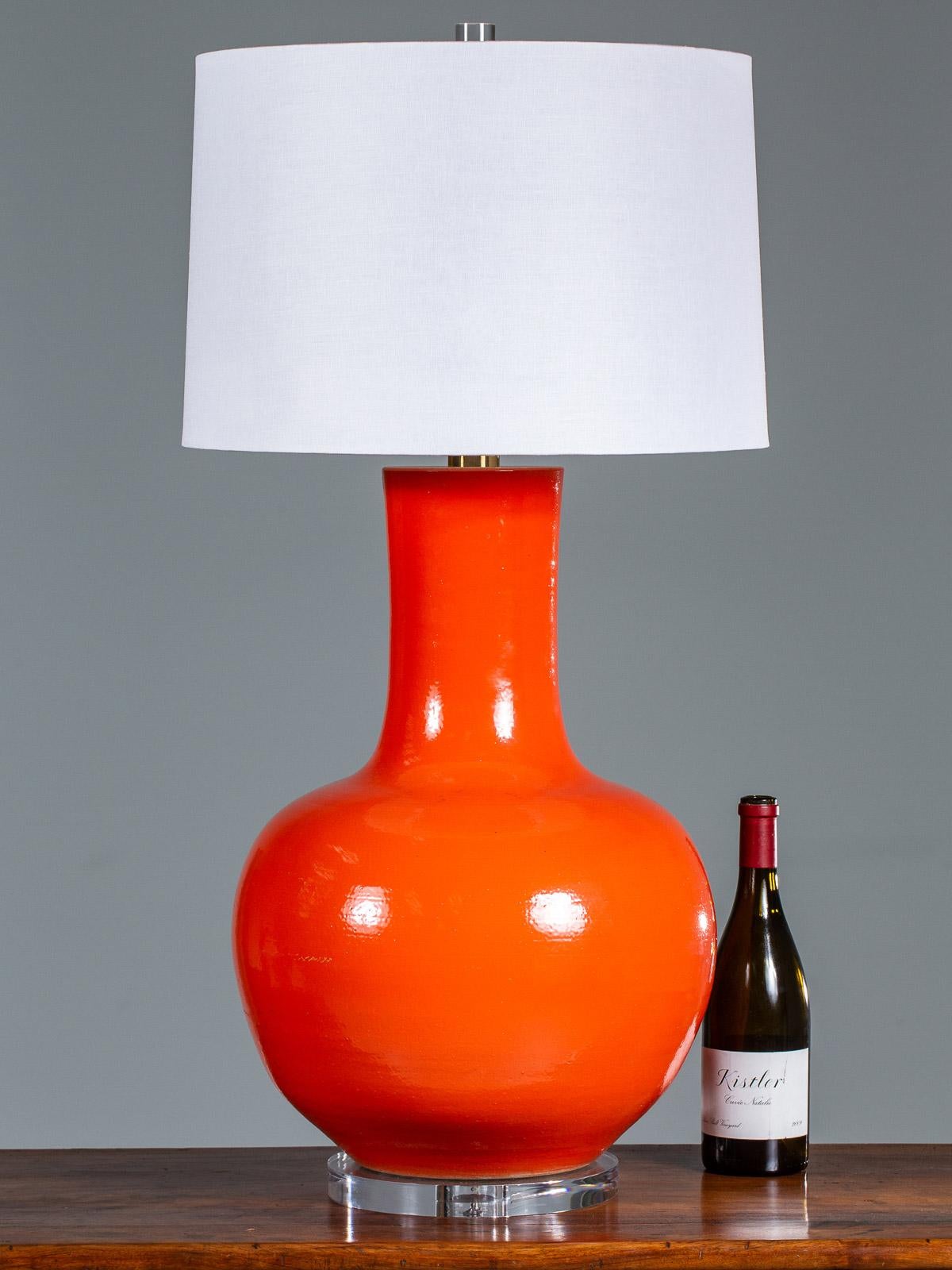 This enormous handmade temple jar vase custom lamp has a delicious persimmon glaze mounted upon a Lucite base. The superb Classic design of the custom lamp is given a modern treatment by the unexpected color of the glaze and the huge scale of the