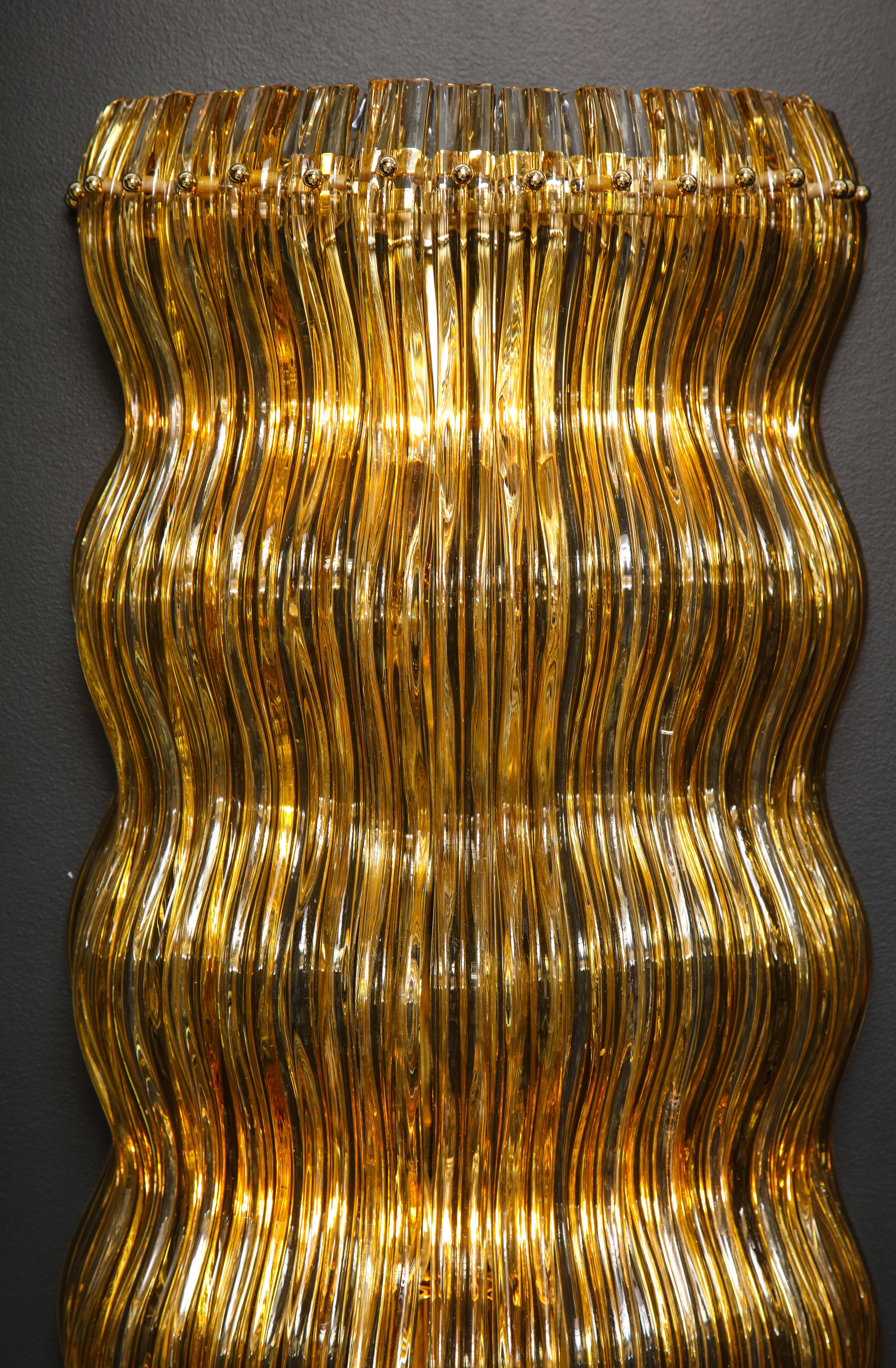 One of kind very large handmade sconces in gold and clear Murano glass in the manner of Venini. Made by a glass master in the last eight remaining original furnaces in Murano, Italy. The glass was shaped while very hot into soft undulating waves,