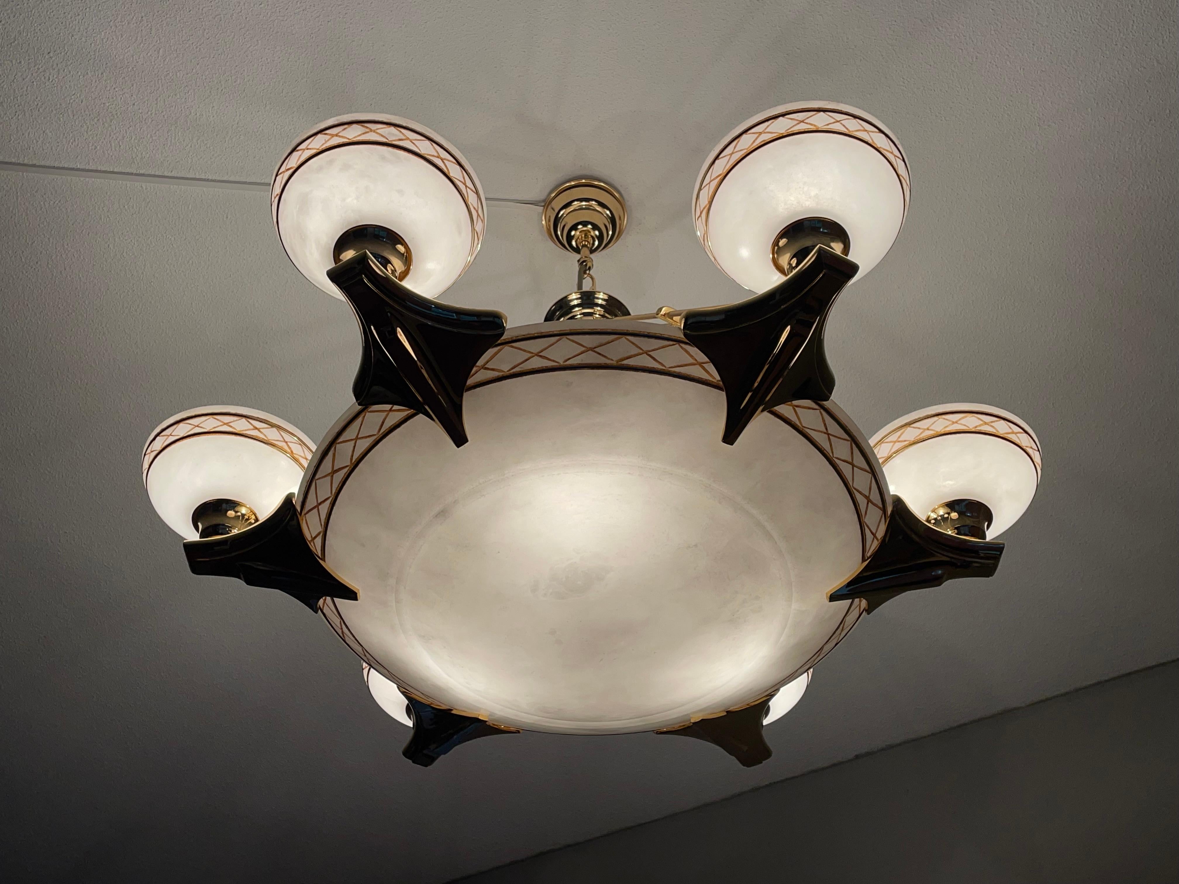 Extra large, excellent condition and great design, 6-arms and 9-light chandelier.

If you like Art Deco style light fixtures with a touch of Hollywood Regency, then this large and rich 1970s alabaster and bronze chandelier could be perfect for