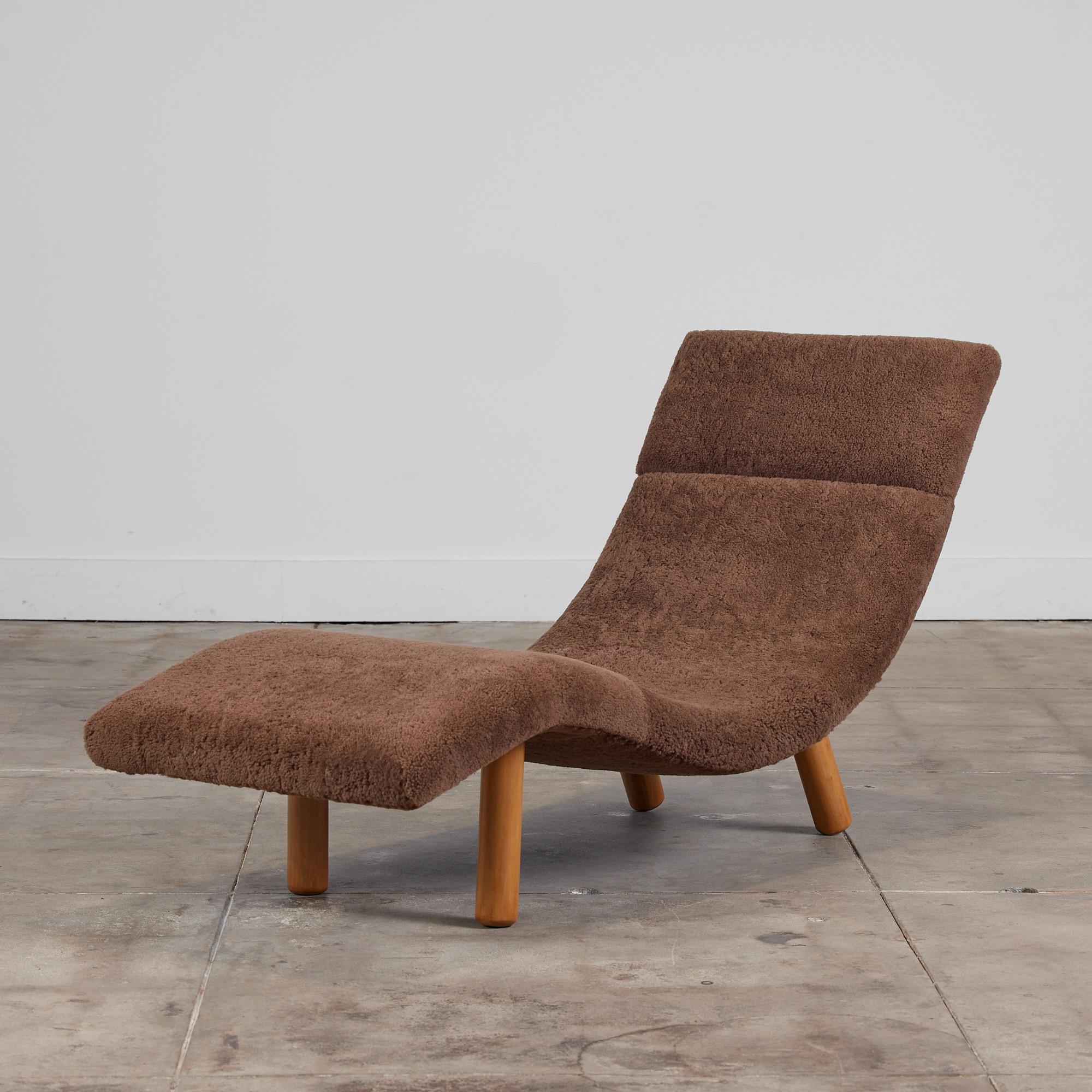 Wave chaise lounge by Enrico Bartolini, c.1970s, USA. The sculptural chaise features a chocolate brown shearling and birch cylindrical legs. The back of the chaise shows two birch wood bars with two metal screw details.

Dimensions: 58