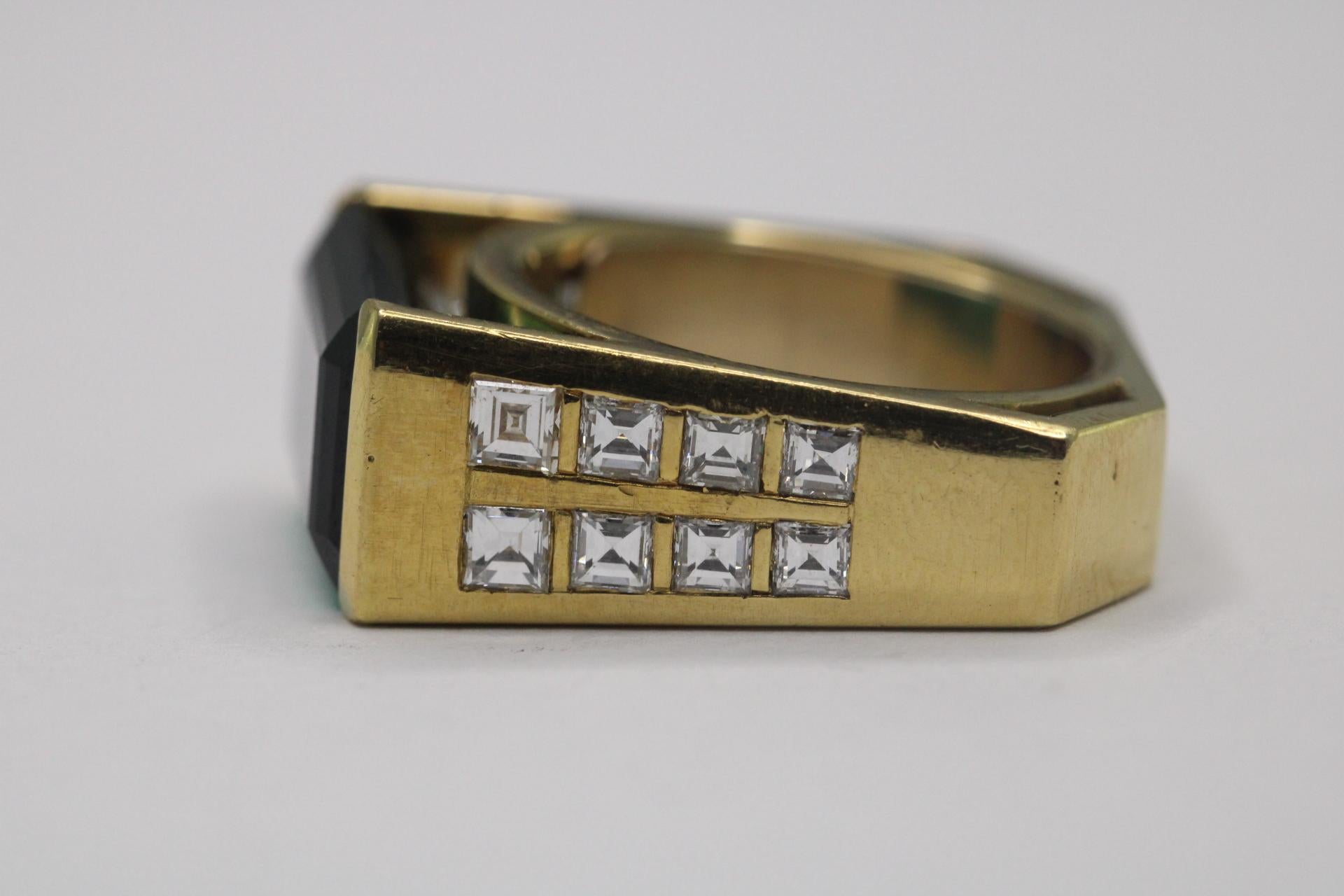 Questo gioiello della metà del secolo scorso presenta una grande tormalina verde naturale con taglio a smeraldo per un totale di circa 6,70 carati, completata da sedici diamanti baguette di forma quadrata per un totale di circa 2,0 carati, colore