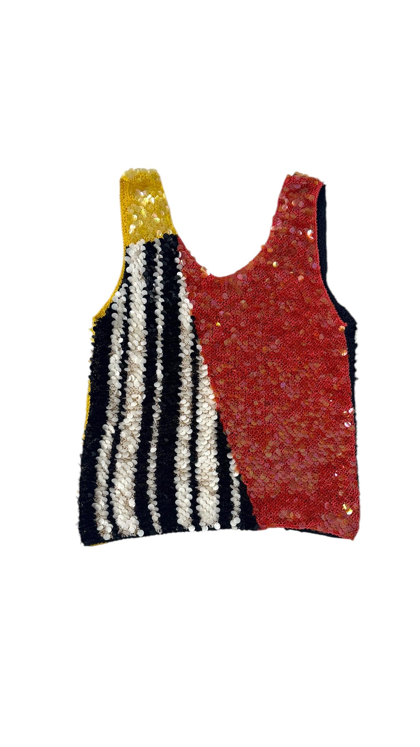 Striking multicolor sequin top from the iconic “Paillettes” line by Enrico Coveri, dating back to the 1980s. This collector’s piece perfectly embodies the spirit of Coveri’s exuberant and maximalist aesthetic, combining bold geometric color blocking
