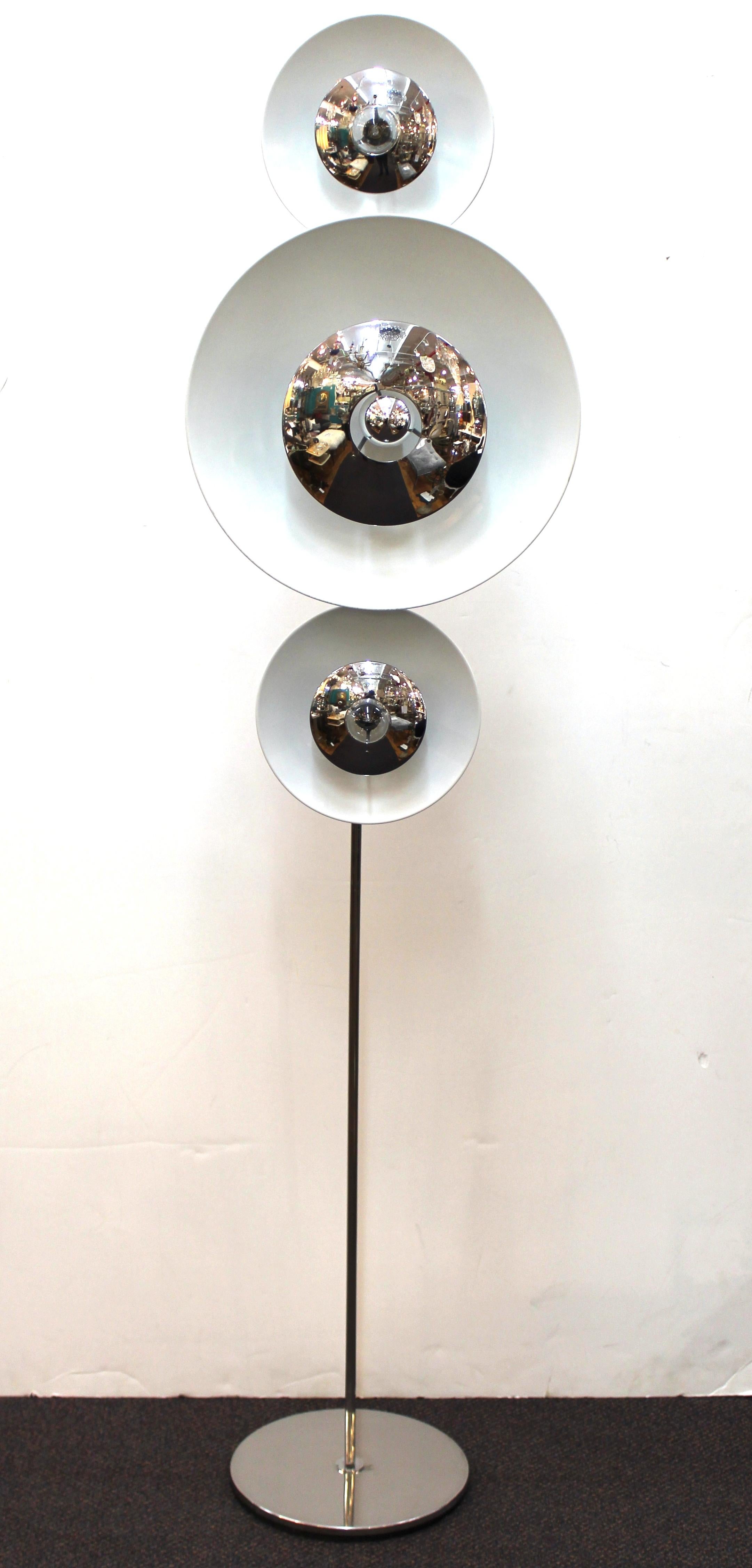 A pair of Italian modern floor lamps designed by Enrico Tronconi in the 1970s. Each lamp consists of three light elements with saucer shaped discs that can be removed and freely re-positioned on the metal rod. Two small discs and one large one per
