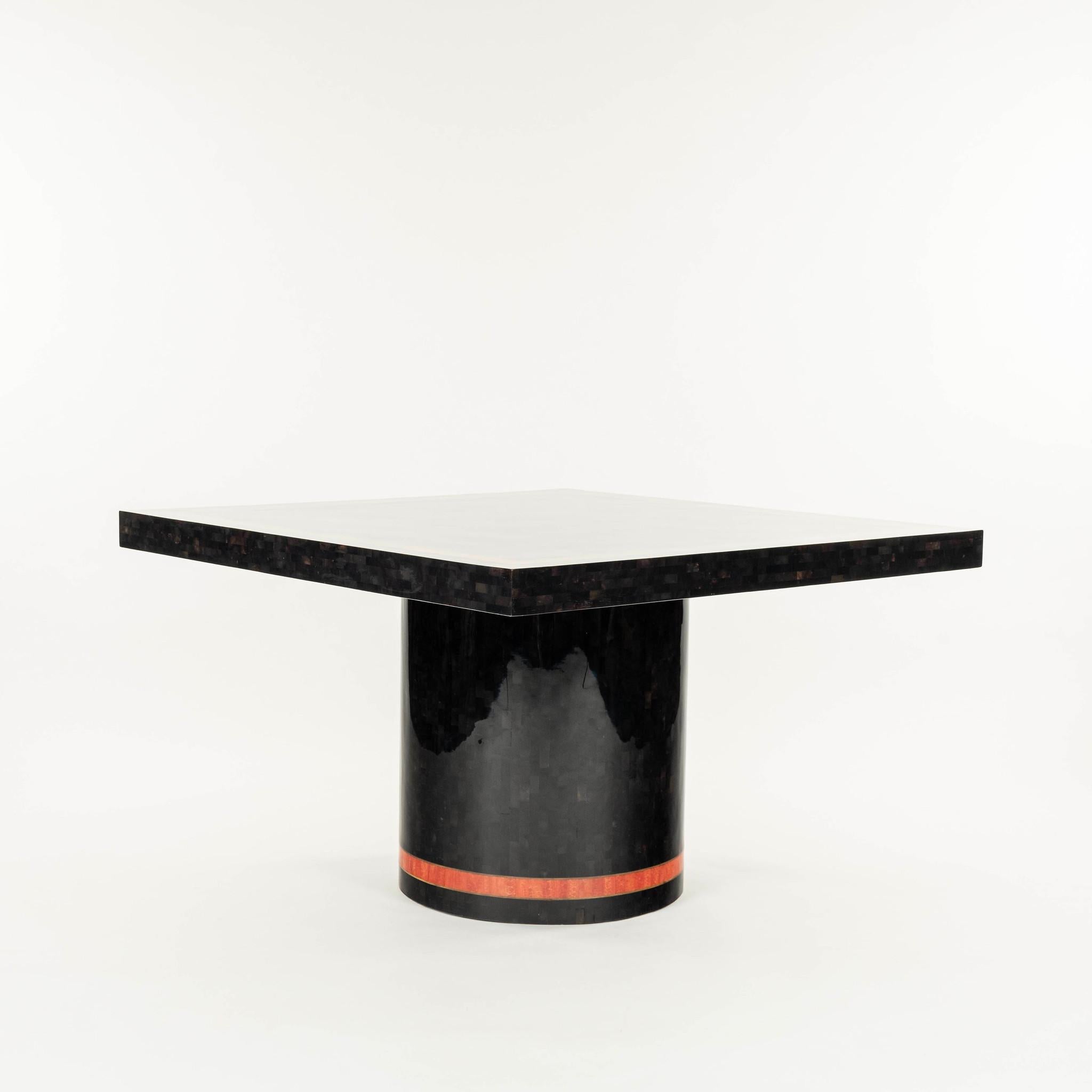 Enrique Garcel style lacquered tessellated horn table featuring a central cylindrical base and orange stone banding with brass inlay.