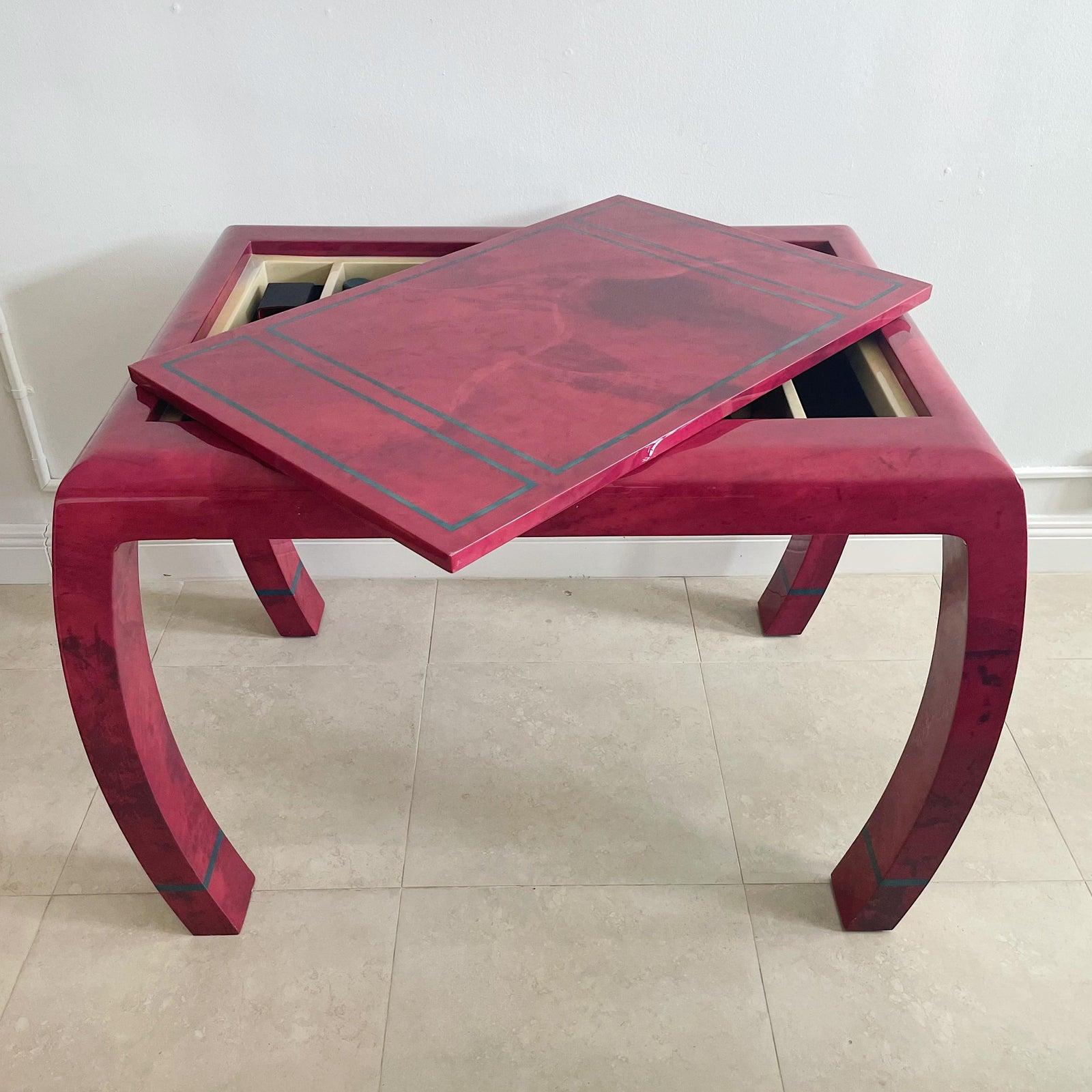 1980's lacquered parchment goatskin with red coloration game table for Enrique Garcel.. With removable reversible top, one side for checkers and the other side plain with a decorative blue parchment inlay. The interior is patterned in red, blue and