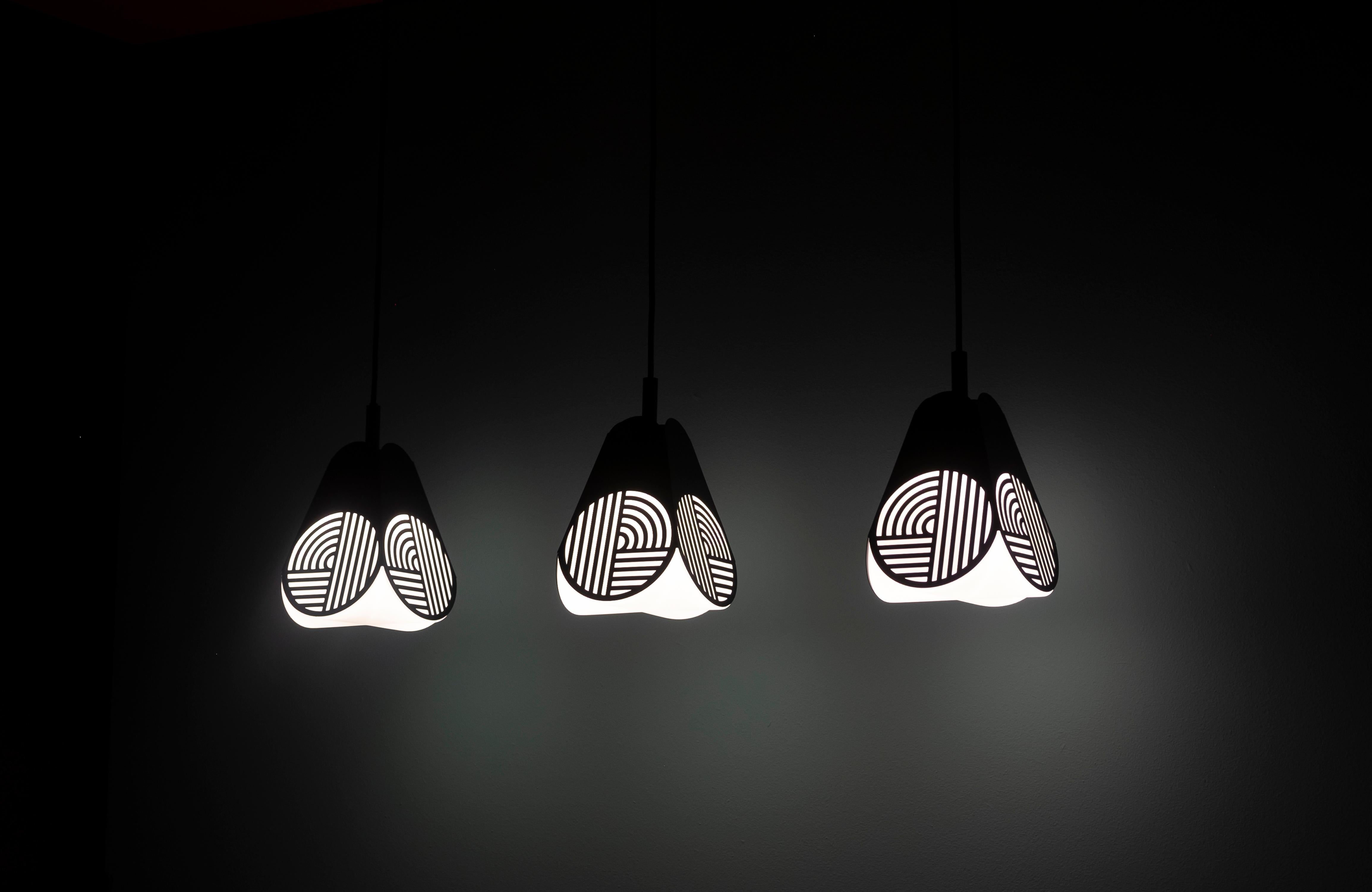 Ensemble of Notic pendant lamps by Bower Studio
Dimensions: 18 x 15.5 cm (Ø) (cord length: 300 cm)

Notic is an homage to classical architectural elements.
The graphical metal shade embraces the complex geometry of the glass and spreads the