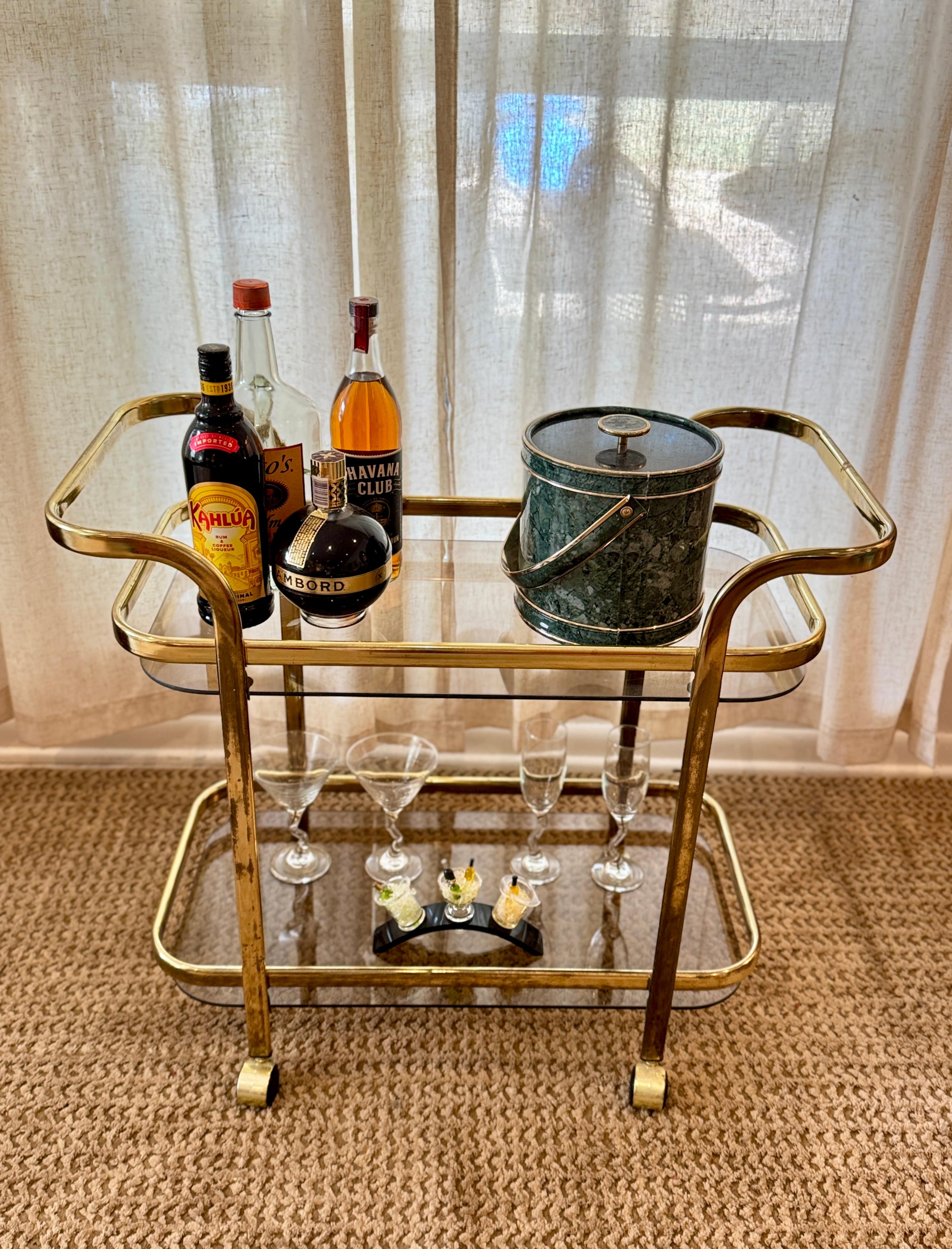 Recibe a tus invitados con estilo con este precioso carrito de bar de dos niveles, de la década de 1980. De metal latonado, con dos estantes de cristal ahumado y cuatro ruedas. En muy buen estado con algunos signos de la edad, ver fotos. 

27