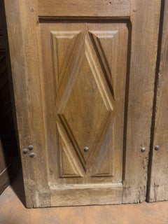 Entrance door in walnut, with two doors and carved panels, Italy