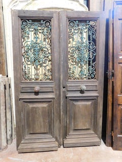 Entrance door, main door in oak wood, two doors, with green iron grille, Italy