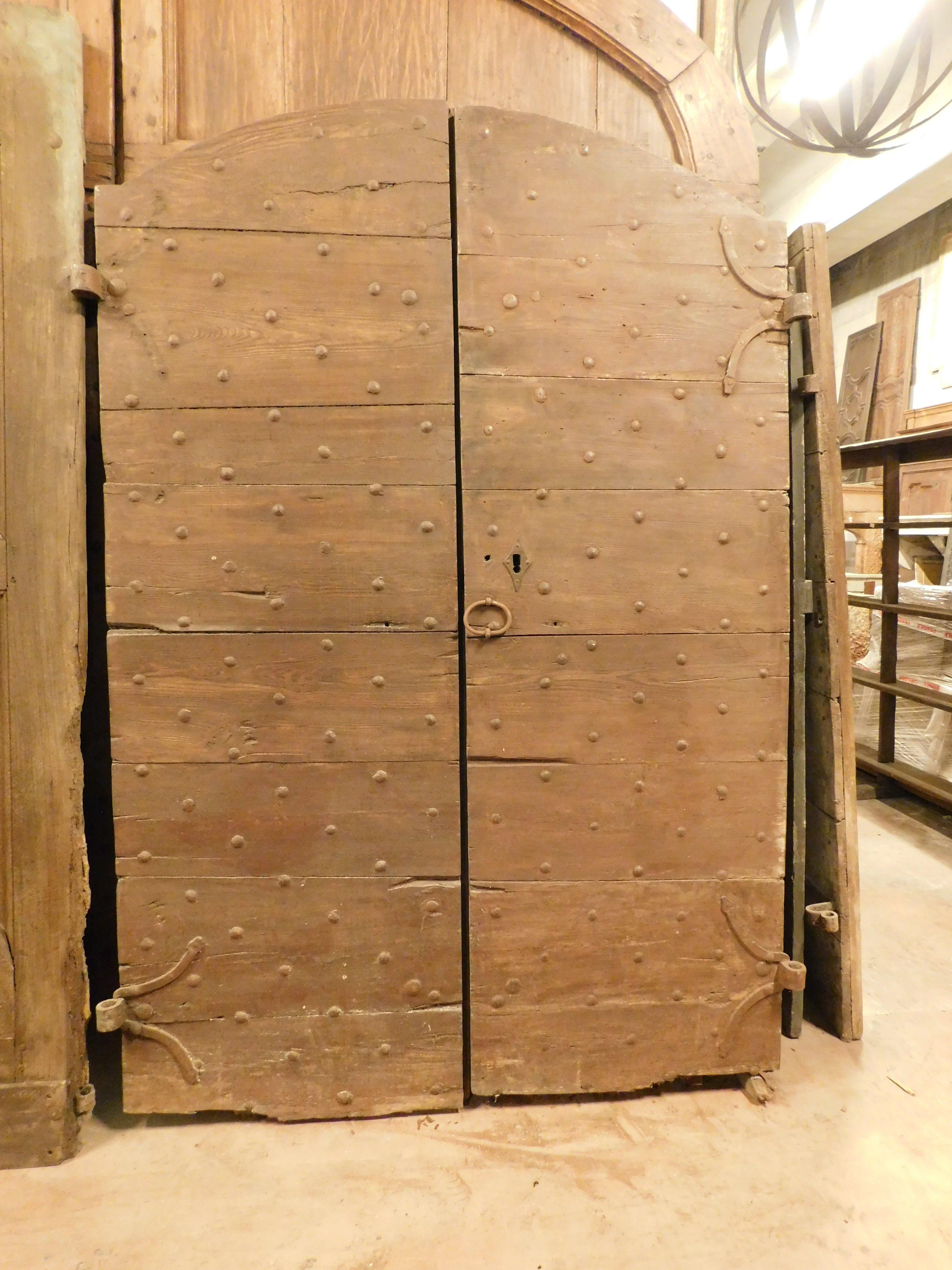 Puerta de entrada antigua, puerta principal rústica de madera maciza de castaño, con dos batientes, arqueada y clavada con clavos originales de hierro, original del siglo XVIII, con apertura de tiro.
Tamaño máximo cm An 152 x Al 231.