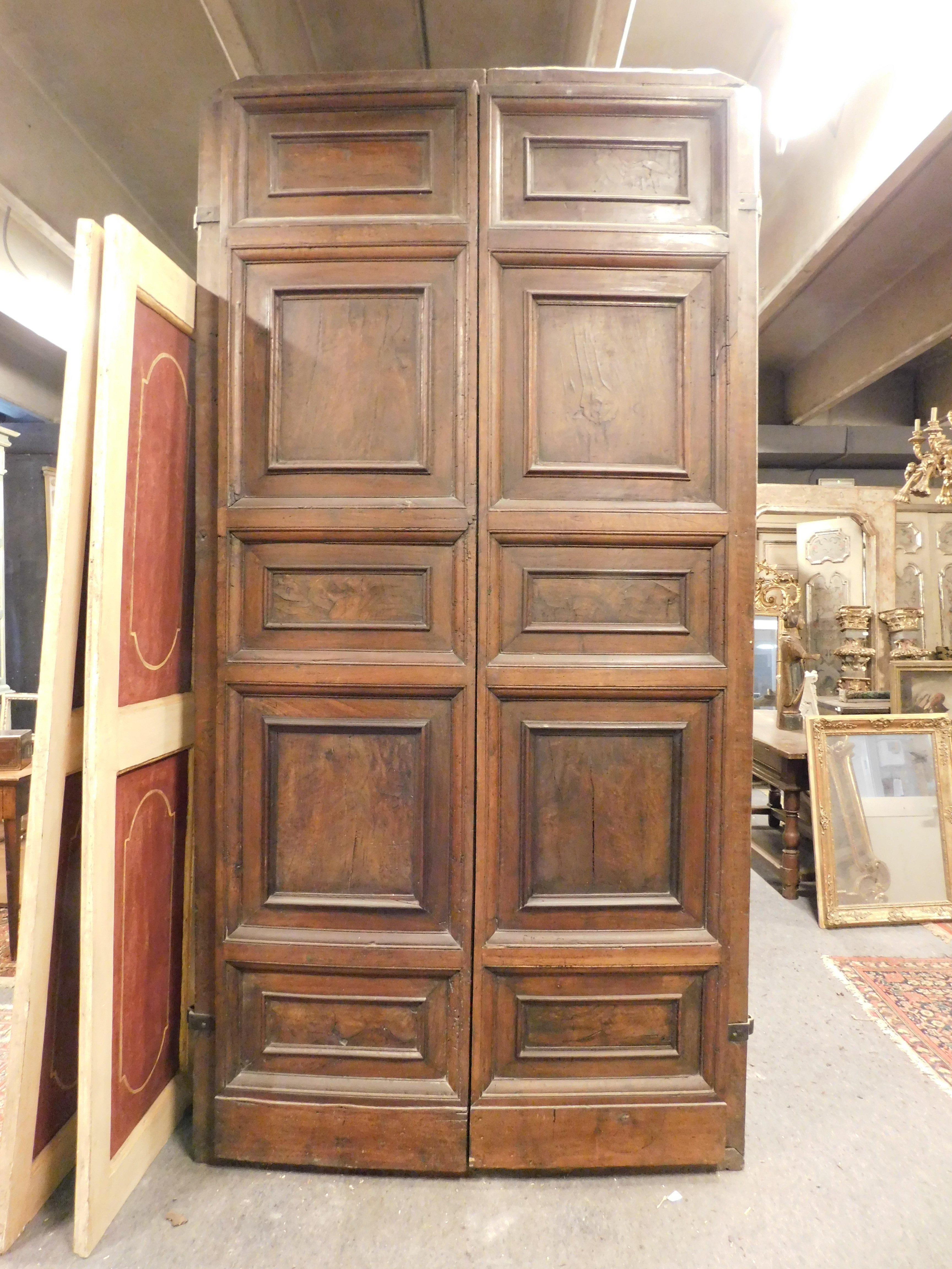 Ancient main entrance door, composed of two doors, hand-carved in precious walnut, very thick and powerful, of great antiquarian value and very very fascinating since it is historic, built for the entrance of a 17th century noble palace in northern