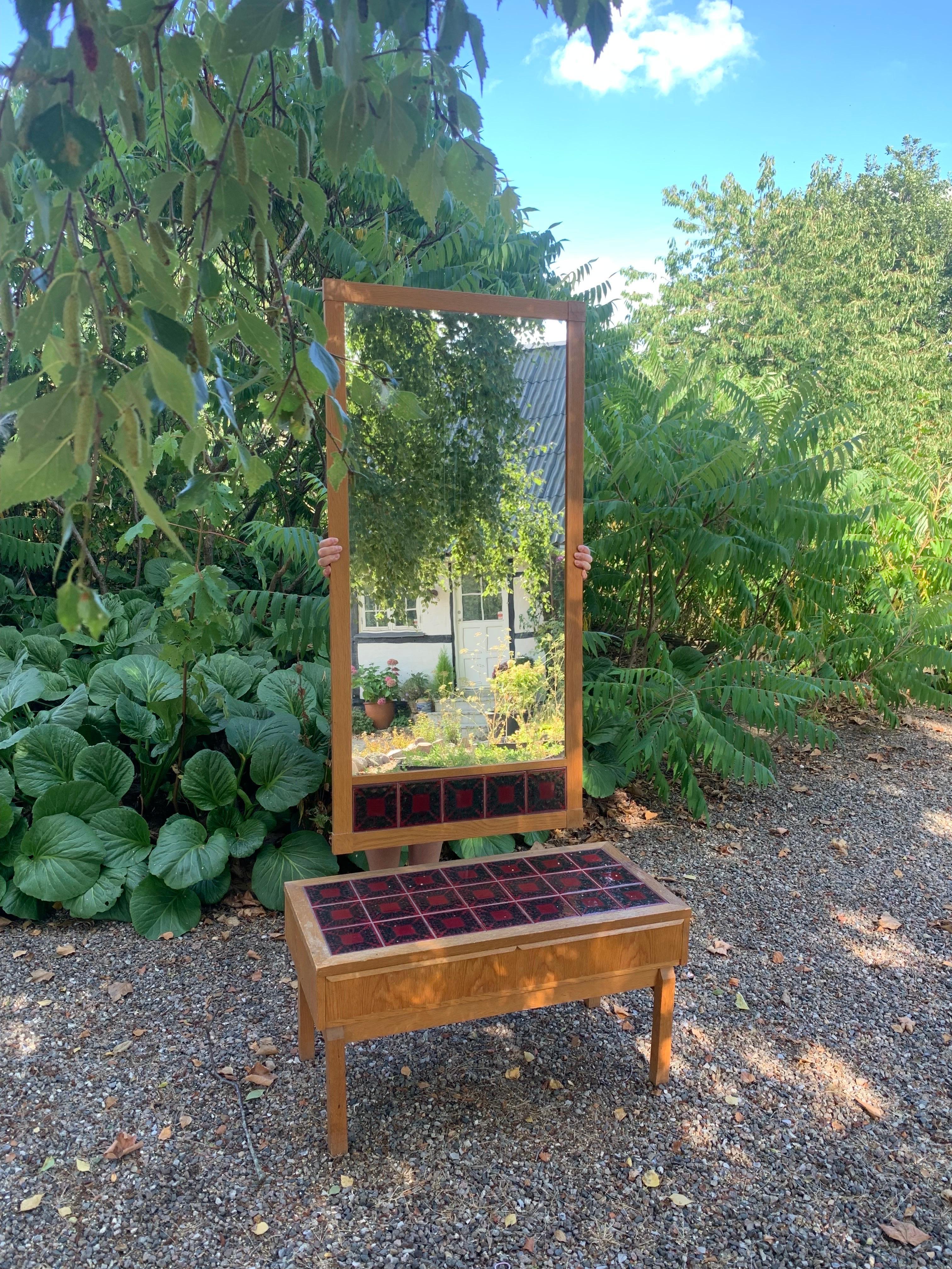 Do you need a nice hall way piece? This could maybe be something for you? It´s a set produced in Denmark in late 60ties (don´t know the designer). A small dresser with 2 drawers and a large mirror In oak with ceramic in red/black colours. 

Good