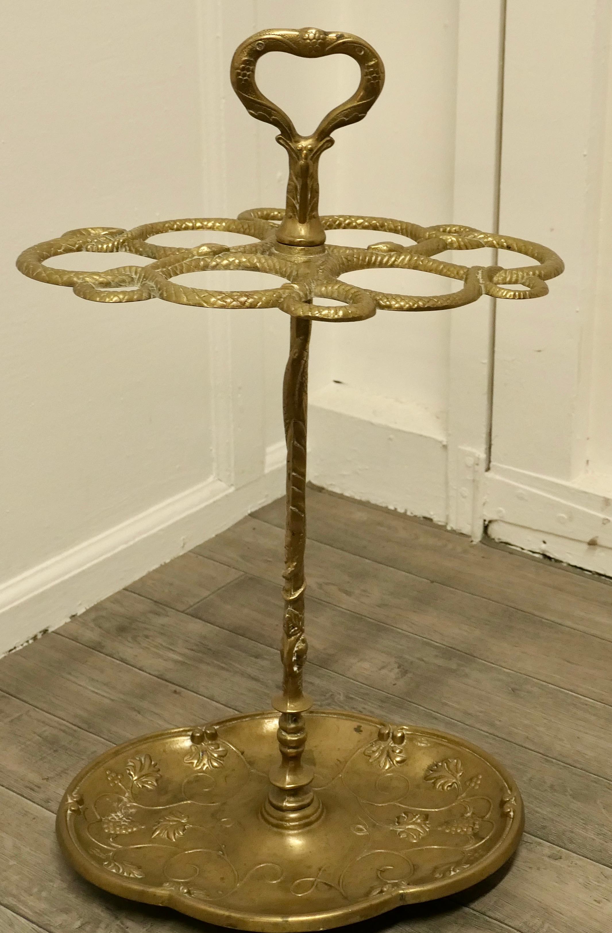 Entwined Snake cast iron brass walking stick stand 

A charming piece with a very unusual shape formed by several snakes winding up from the bottom and then twisting to make the holders for the sticks and umbrellas
The heavy brass base is a drip