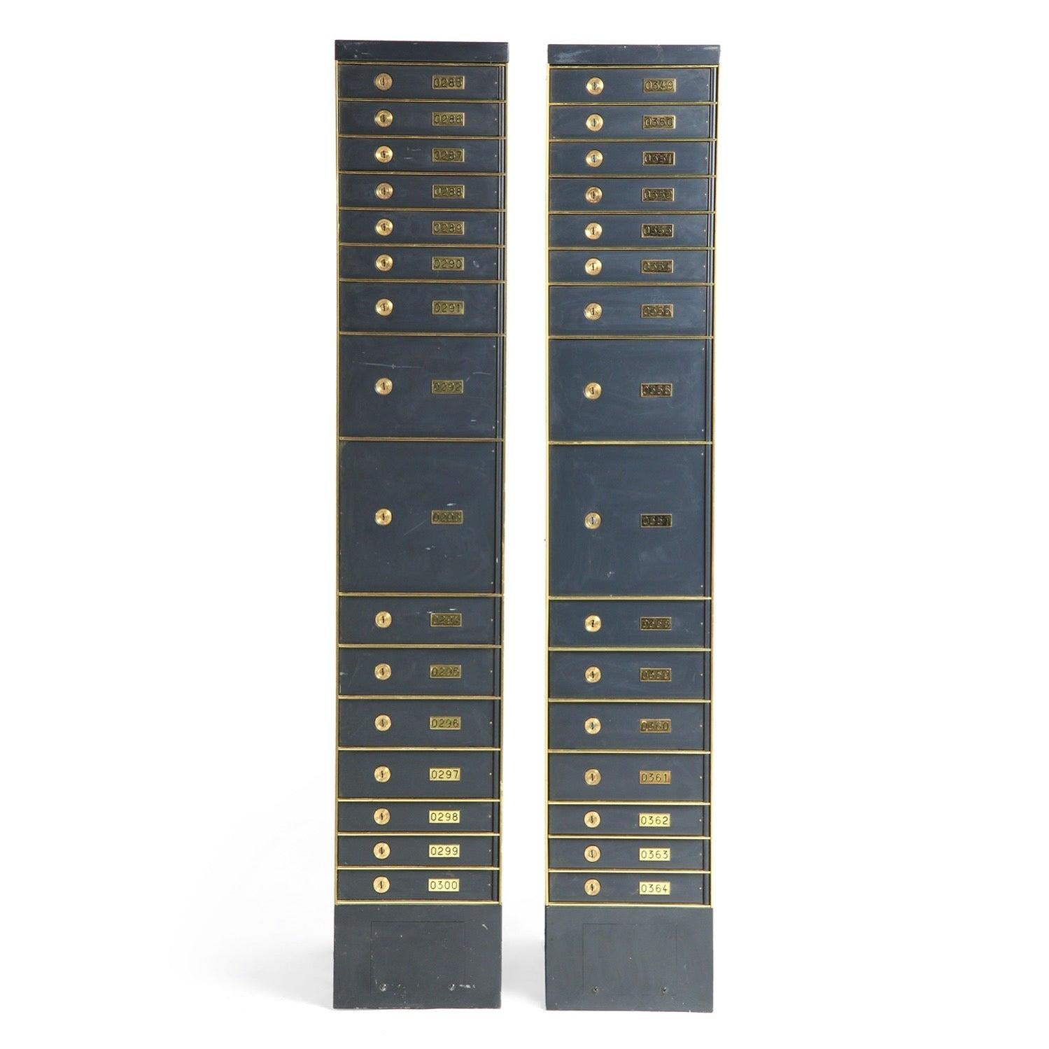 An unusually tall and narrow enumerated stacked safety deposit box crafted of painted steel with brass details.
