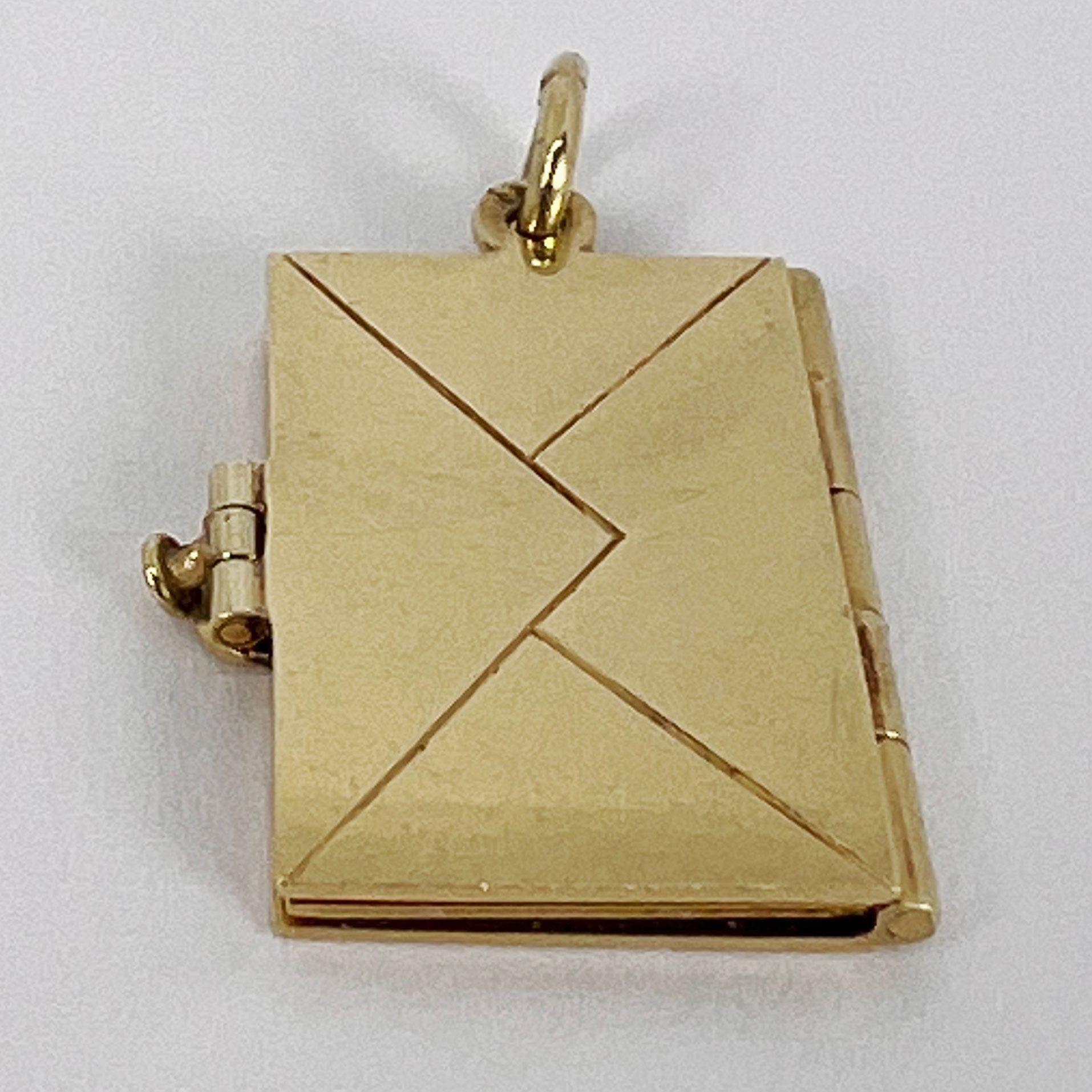 A 14 karat (14K) yellow gold charm pendant designed as an envelope with an enamel stamp which opens to show a letter page. Stamped 14K for 14 karat gold to the jump ring. Unengraved.

Dimensions: 2 x 1.4 x 0.2 cm (not including jump ring)
Weight:
