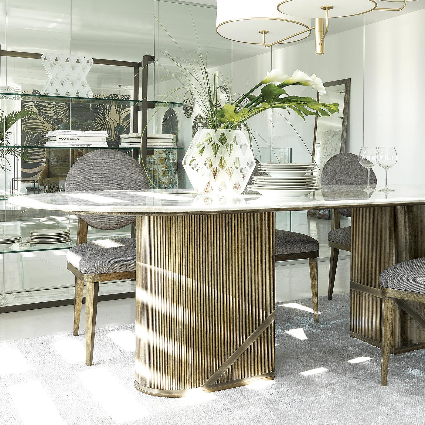 Complément superbe de la bibliothèque Enveloppe, cette superbe table à manger est un ajout magnifique à une maison moderne ou contemporaine. Le plateau elliptique en marbre exquis Calcatta Oro donne une allure somptueuse à la pièce et les veines