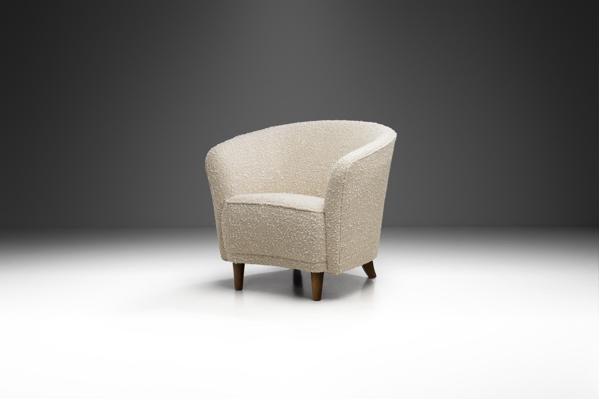 D'apparence élégamment cosy, cette chaise est un exemple stylisé du côté esthétique doux et courbé du modernisme du milieu du siècle en Europe. Adoptant la tendance d'abandonner l'ornementation au profit de la forme, le concepteur de cette chaise a