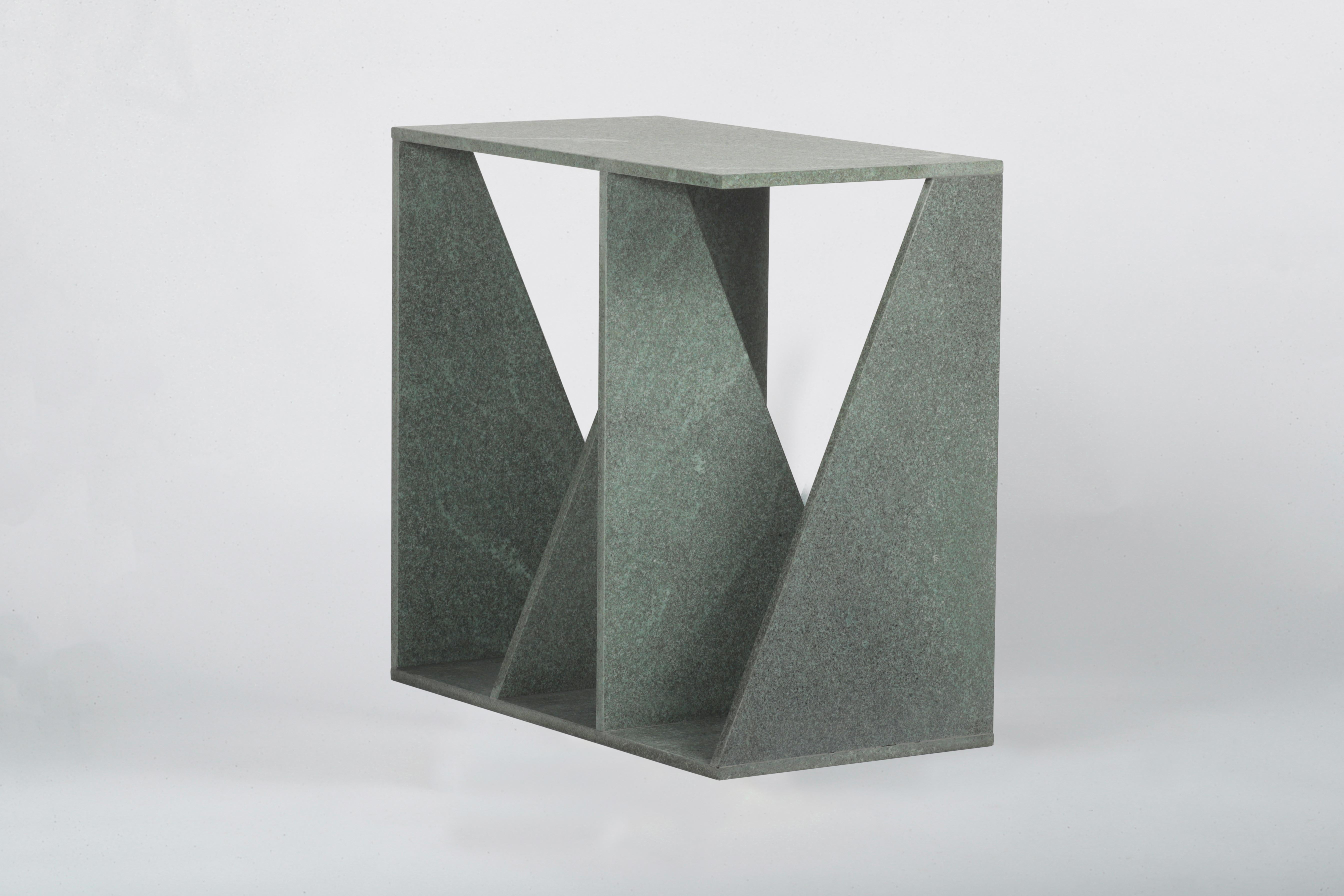 Les couches de pierre mènent à un but fonctionnel en créant un support pour une table d'appoint. La forme géométrique sculpturale de ce meuble permet un petit rangement grâce à son design. Envo est une table d'appoint qui peut également être