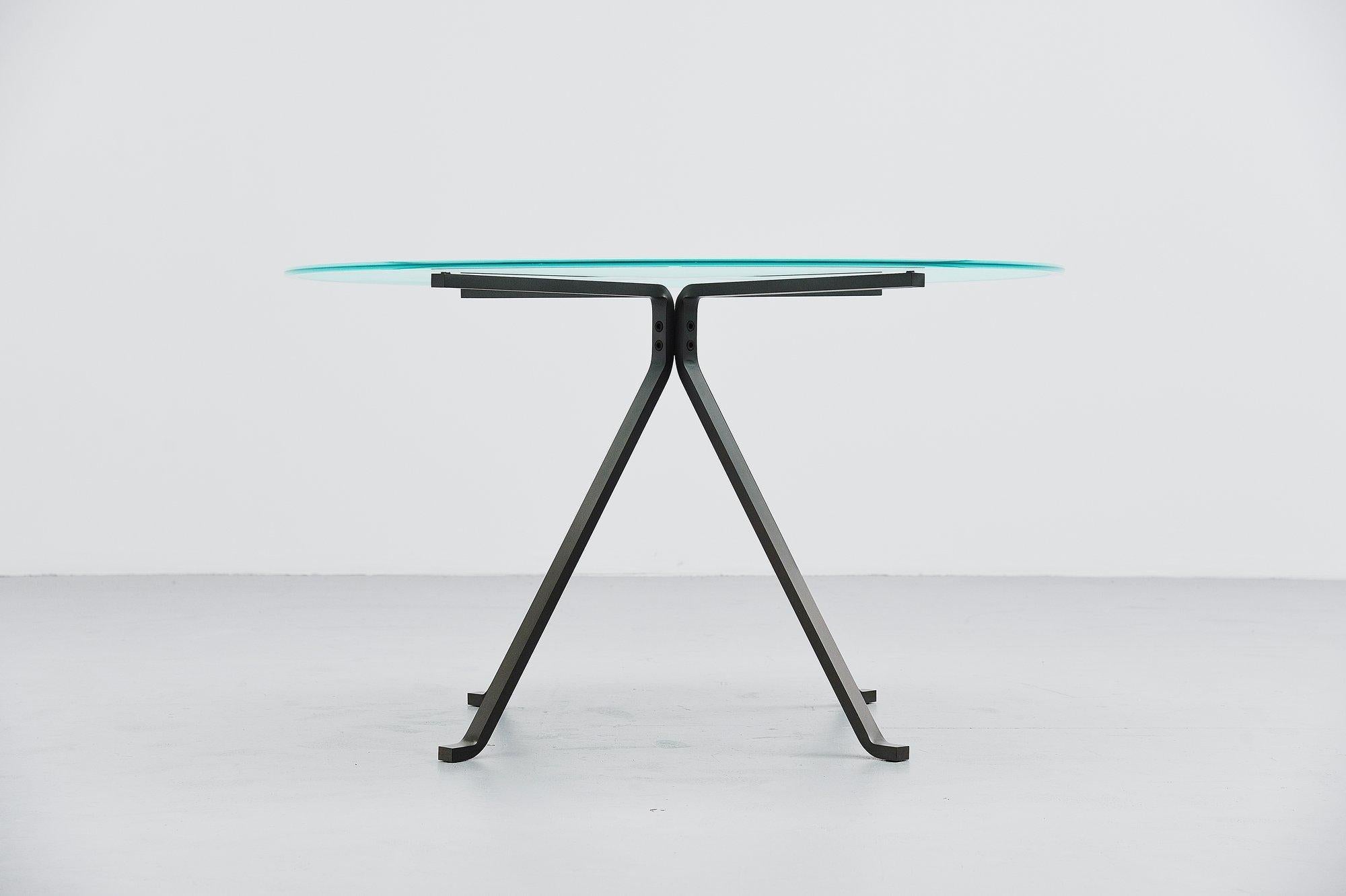 Very nice minimalistic dining table designed by Enzo Mari and manufactured by Driade, Italy, 1973. This table has heavy solid metal folded frame and a partially sanded round glass top which looks really nice. The tables is in very good original