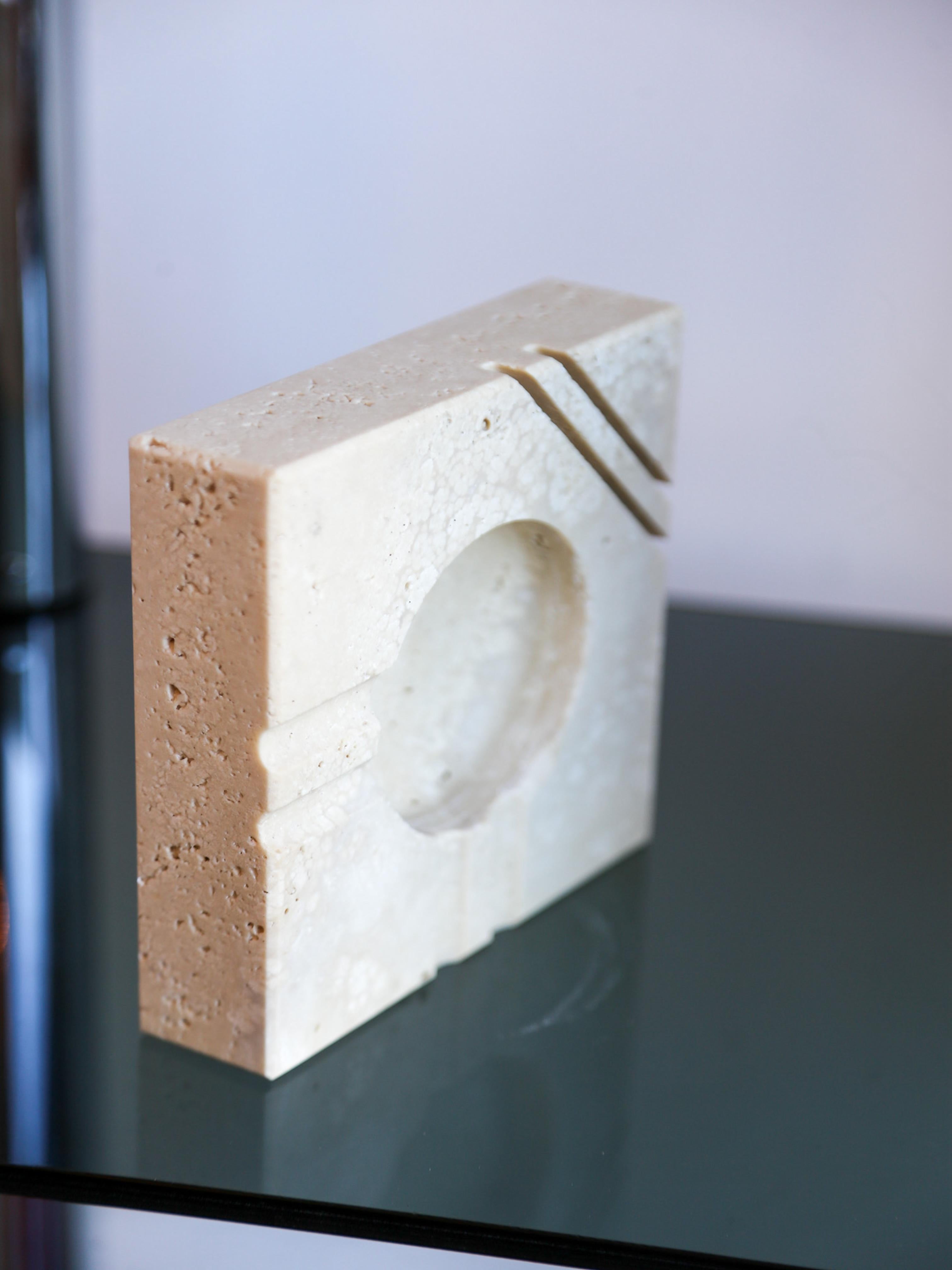 Designed by Enzo Mari for Fratelli Mannelli. A perfect blend of form and function, this mid-century Italian piece features a sculptural geometric design with natural stone variations, making each piece unique. Crafted from high-quality travertine,