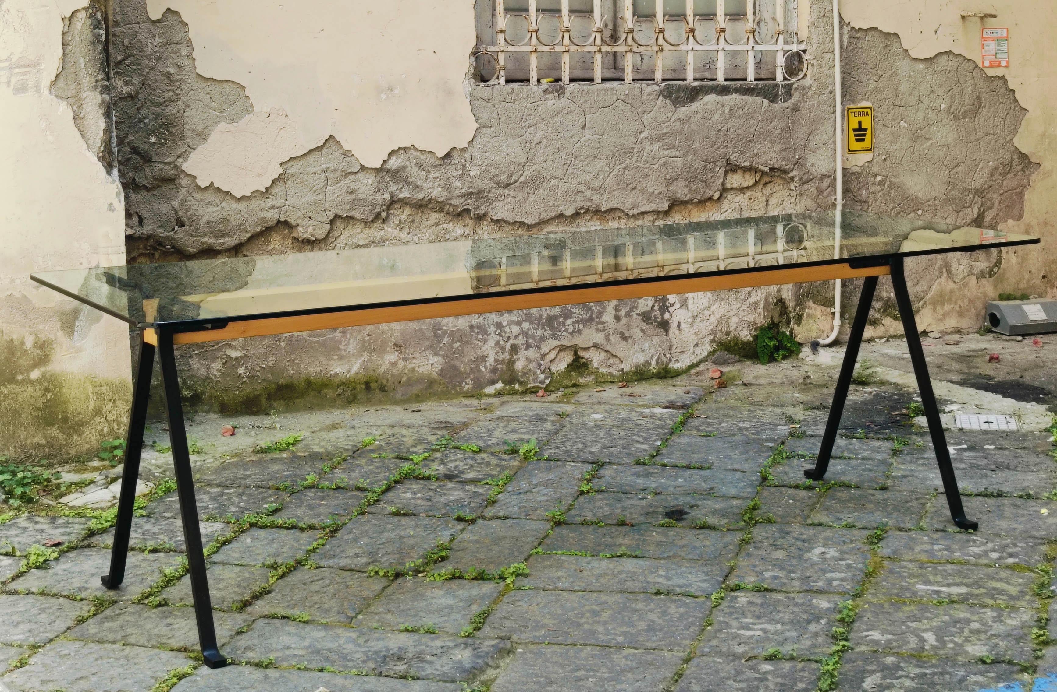 Dining table mod. Frate with rectangular tempered glass top with rounded corners. The central structure consists of a solid wood beam that connects to anthracite black painted steel legs.
Produced by Driade  and designed by Enzo Mari in 1973.
Very