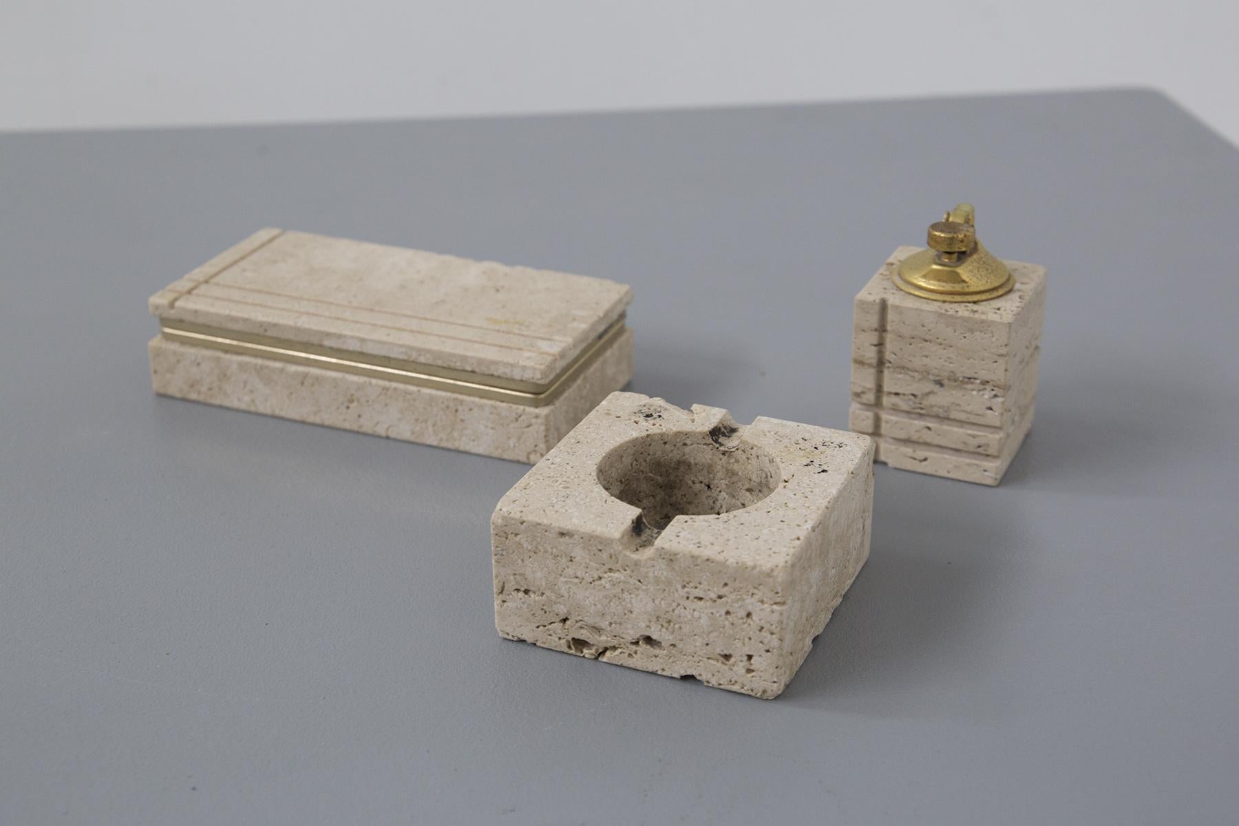 Fascinating travertine smoking set designed by the great Enzo Mari in the 1970s, of fine Italian manufacture. The brass hallmark is present.
The set is entirely made of elegant light travertine and brass. There are four pieces: the ashtray, square