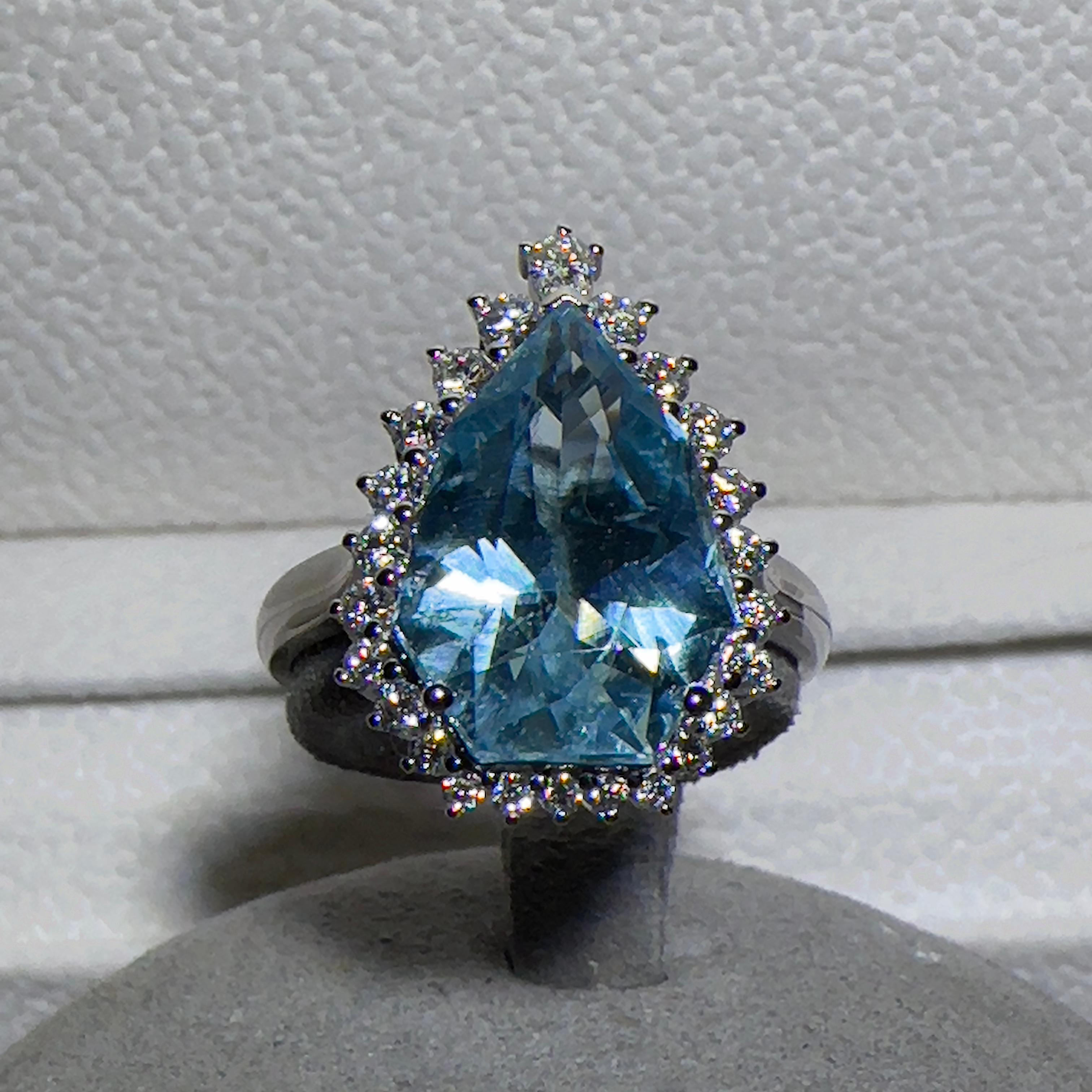 This is a unique shield cut aquamarine and diamond ring. The shield cut aquamarine is not commonly found in the market, and is often only available through custom cutting. Shield has been a long time been regarded as a symbol of protection. Shield