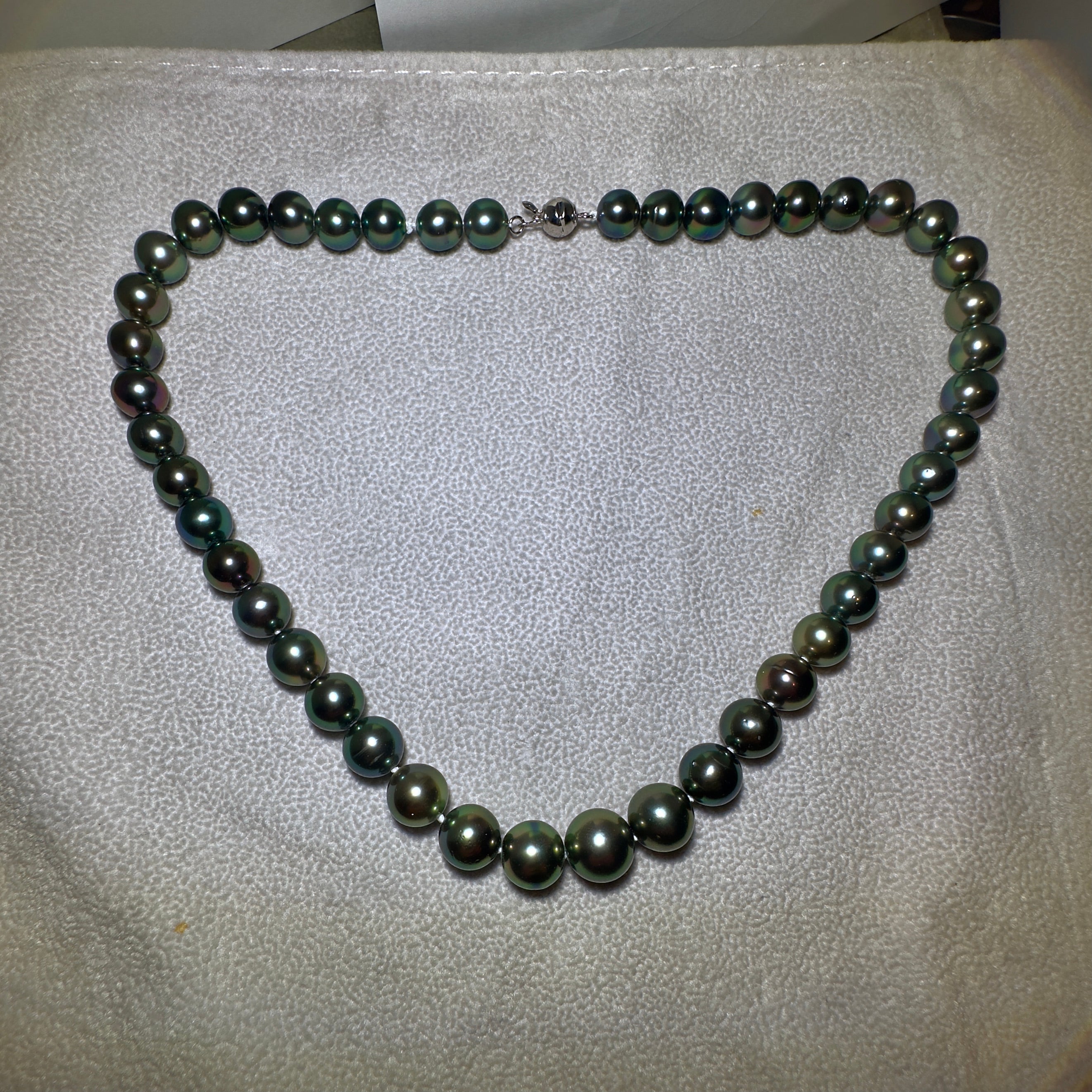 A Strand of black Colour Green tone Tahitian pearl necklace with 18K Gold Clasp. Green tone is very sought after in Tahitian pearls and therefore more valuable. 

A 10.4 mm to 13.5 mm black Colour Green Tone Tahitian Pearl Necklace. It is a very