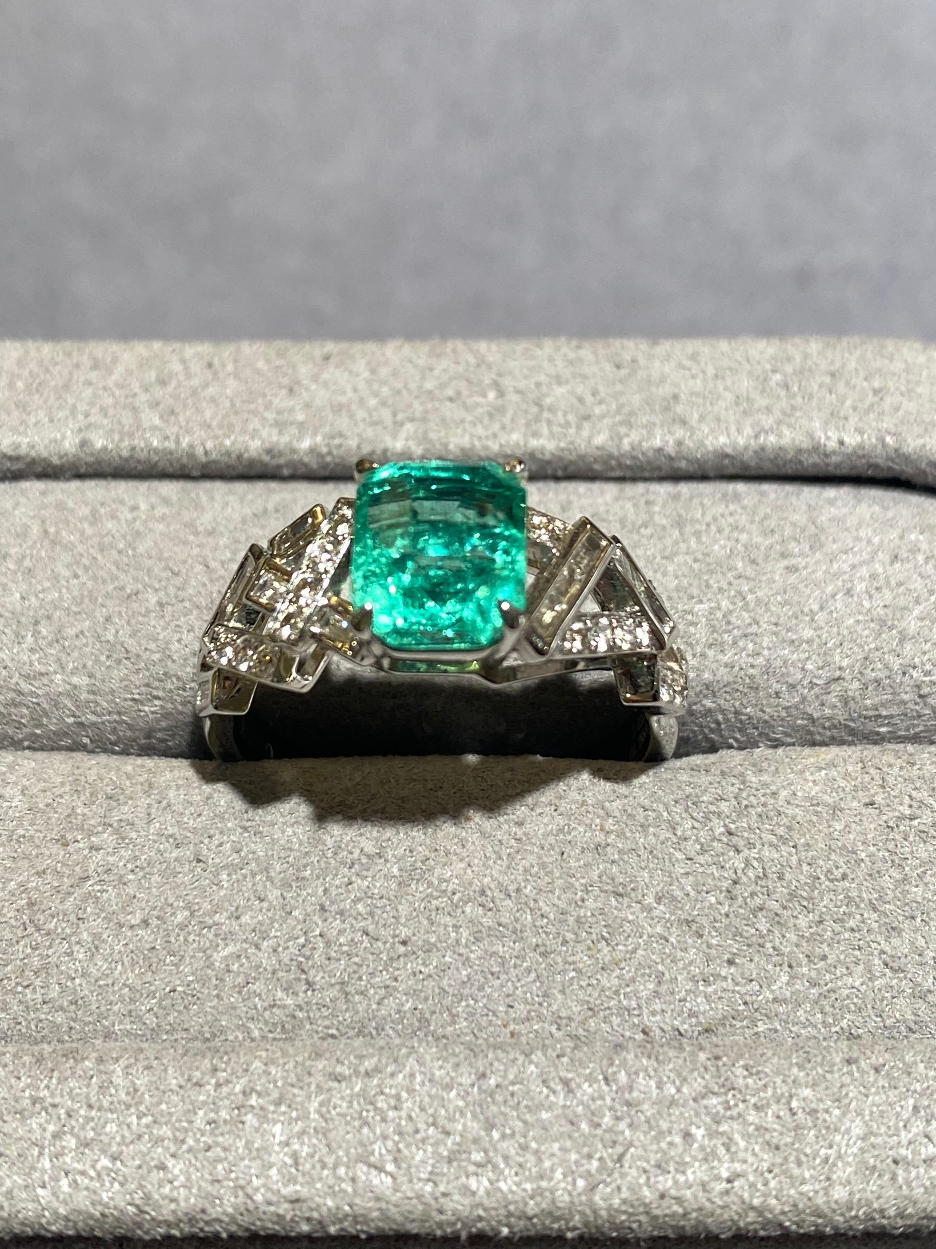 A 2.03 ct Emerald and diamond ring in 18k white gold. It is a geometric design ring with the band of the ring made up by lots of rectangular cube. Those cubes are set with baguette and brilliant cut round diamond. It is a very modern design that