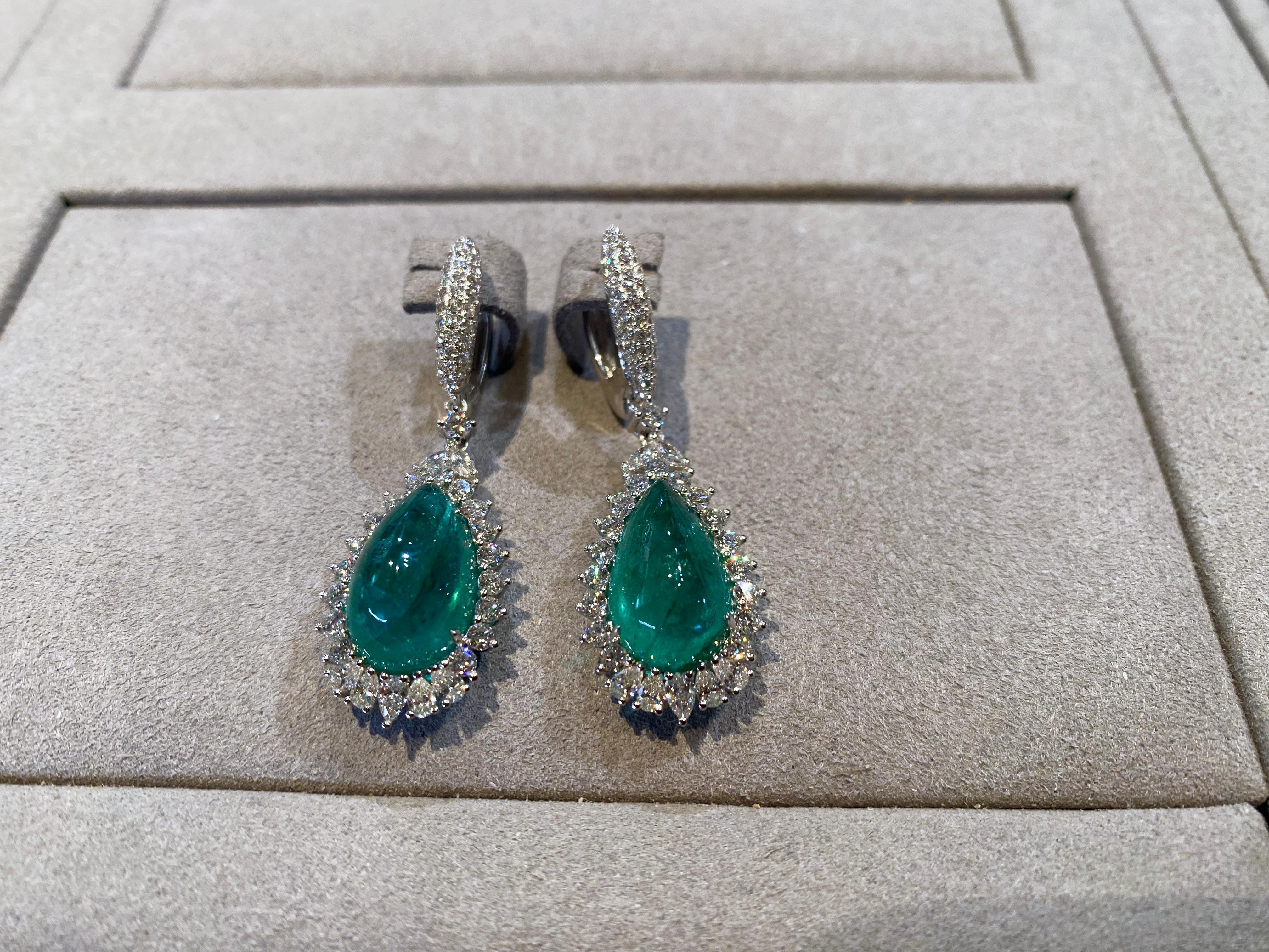 This is a Pair of Dangle Earring consists of 16.79 ct of Emerald Cabochon.  Around each Emerald there is circle of diamond pave, those diamonds are very important in reflecting fire and brilliance as the sugarlof and cabochon cutting doesn't come