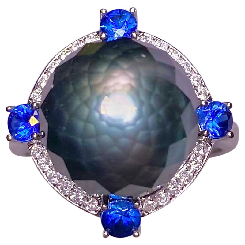 Anello Eostre con perle nere di Tahiti sfaccettate, zaffiri e diamanti in oro bianco