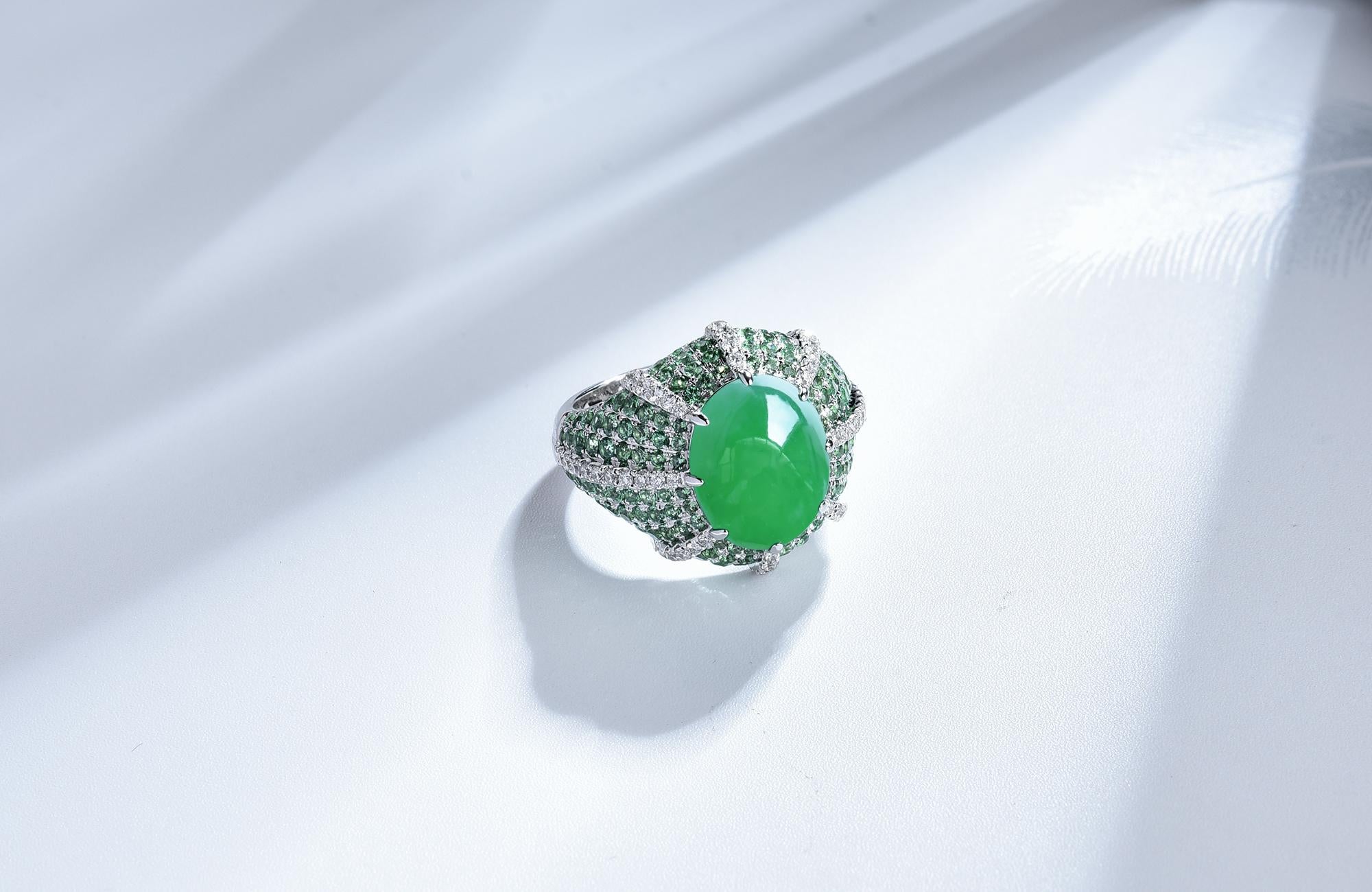 This is a vivid green jadeite cabochon diamond ring. The Jadeite is surrounded by Tsavorite and Diamond pave. The design bears resemblance to the dragon's claws holding the Holy Grail, Enigmatic yet modern. In order to stand out from the Tsavorite