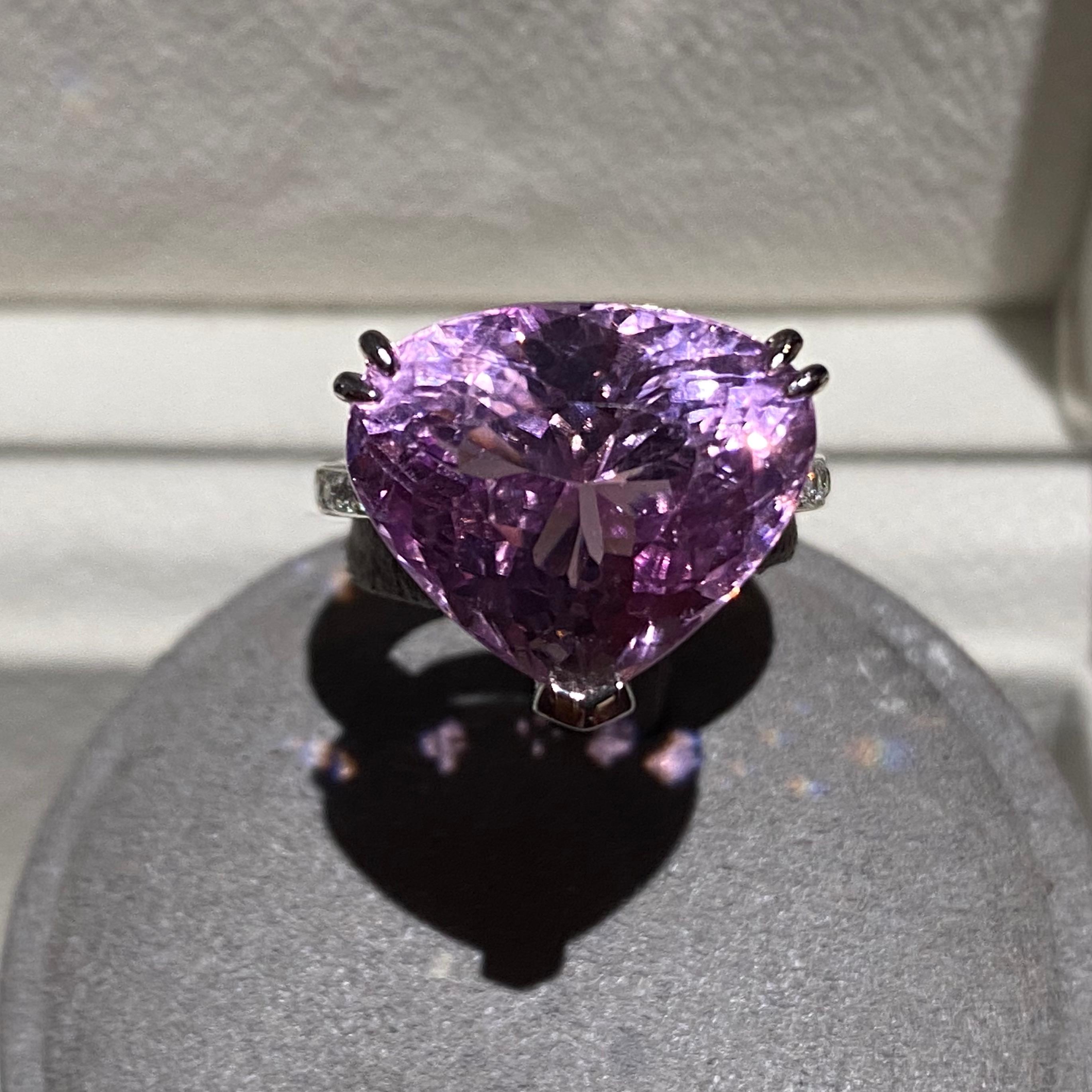 Dies ist ein auffälliger Cocktailring, da der Hauptstein Kunzit über 15ct wiegt und eine schöne rosa-violette Farbe hat. Der Farbton des Kunzit ist eher hell, was dazu führt, dass er eine eher lässige/niedliche Ausstrahlung hat und zu einem eher