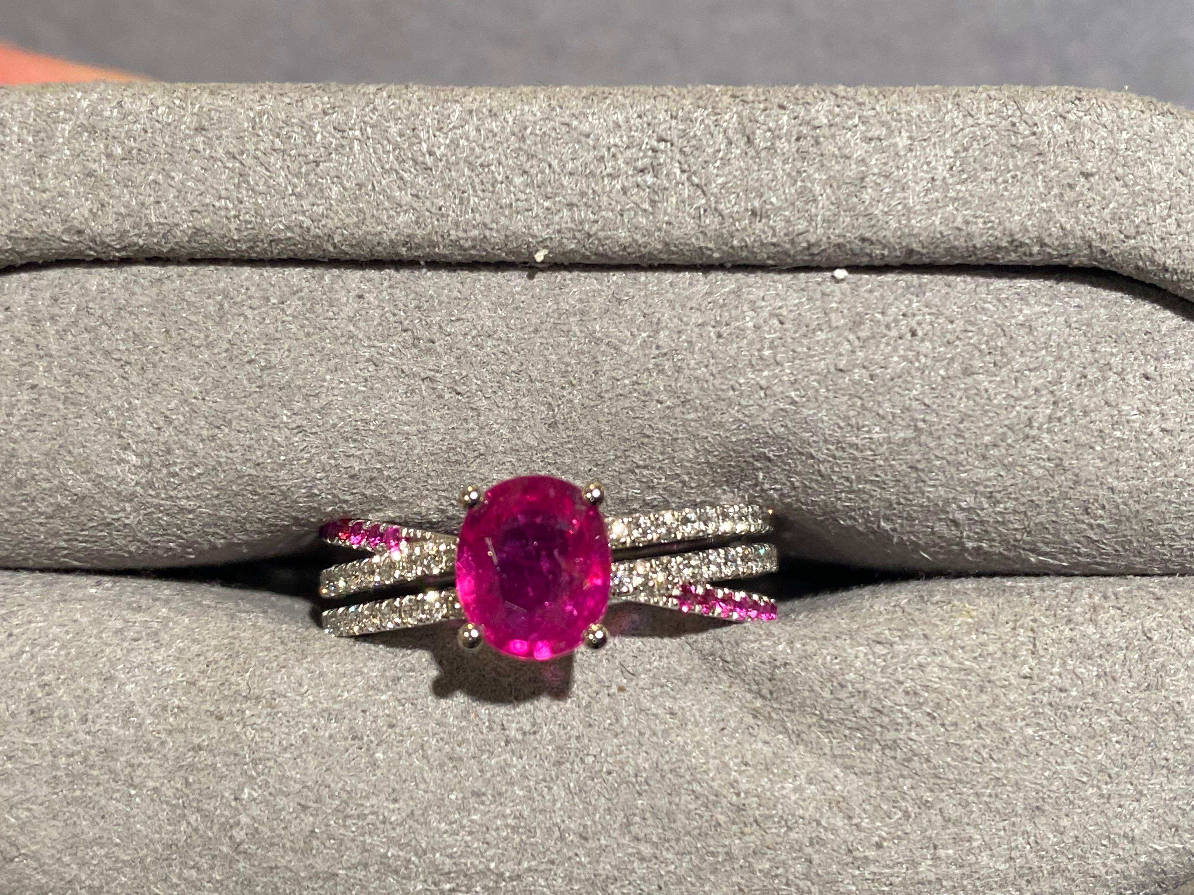 A 1.27 ct purplish pink sapphire and diamond ring in 18k white gold. The main purplish pink sapphire is secured by 4 white gold claws and the band of the ring is made up of 3 individual pave bands. The 2 diamond pave bends are parallel to each other